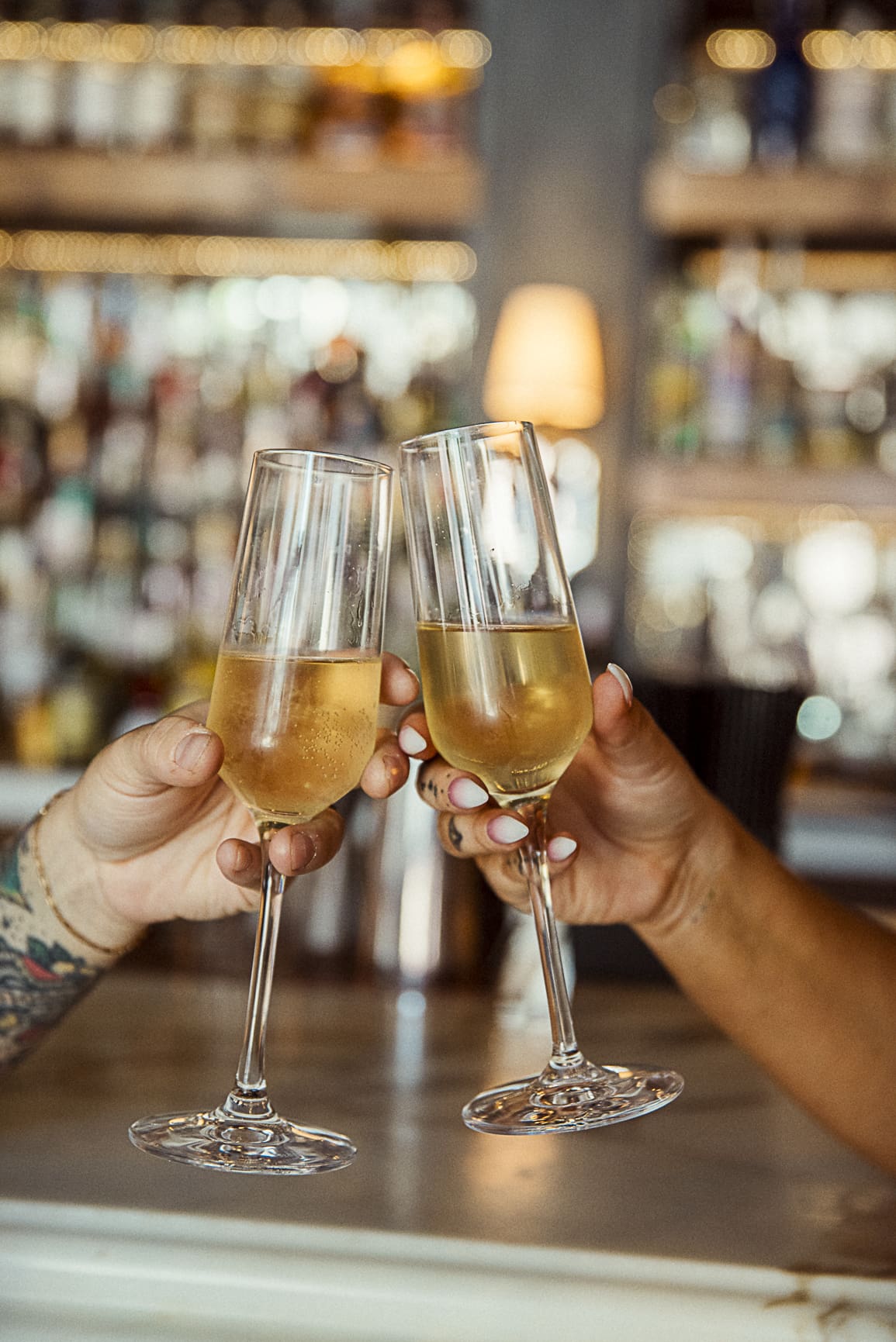 Close-up of champagne glasses clinking during a post-elopement celebration at a downtown St. Augustine bar. 