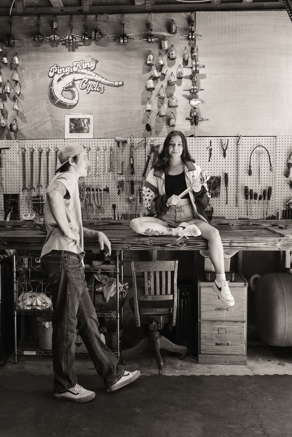 Couple posing in a creative workshop setting with tools and industrial textures for a unique engagement session
