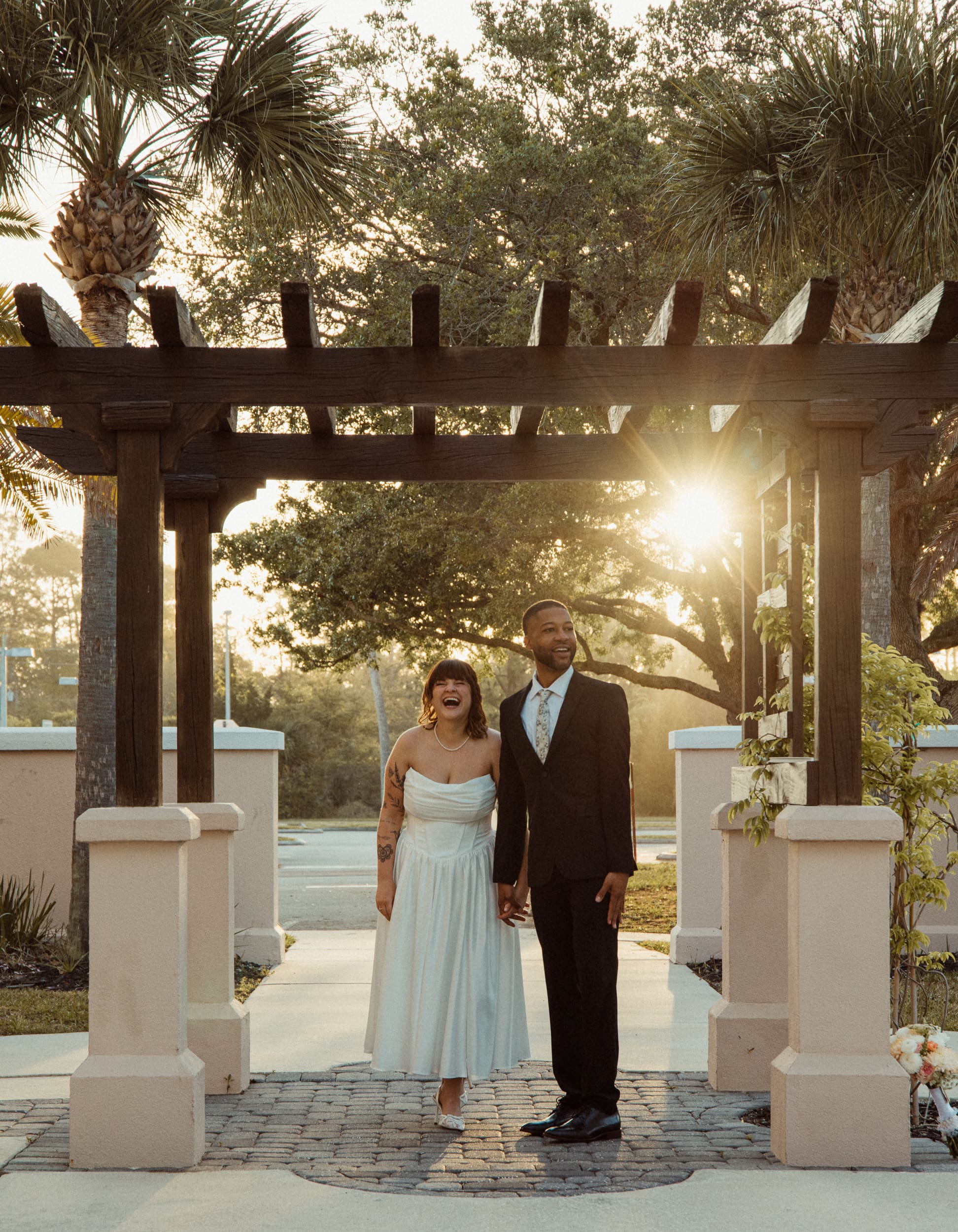 Couple standing under pergola at sunset after St Augustine courthouse elopement. 
