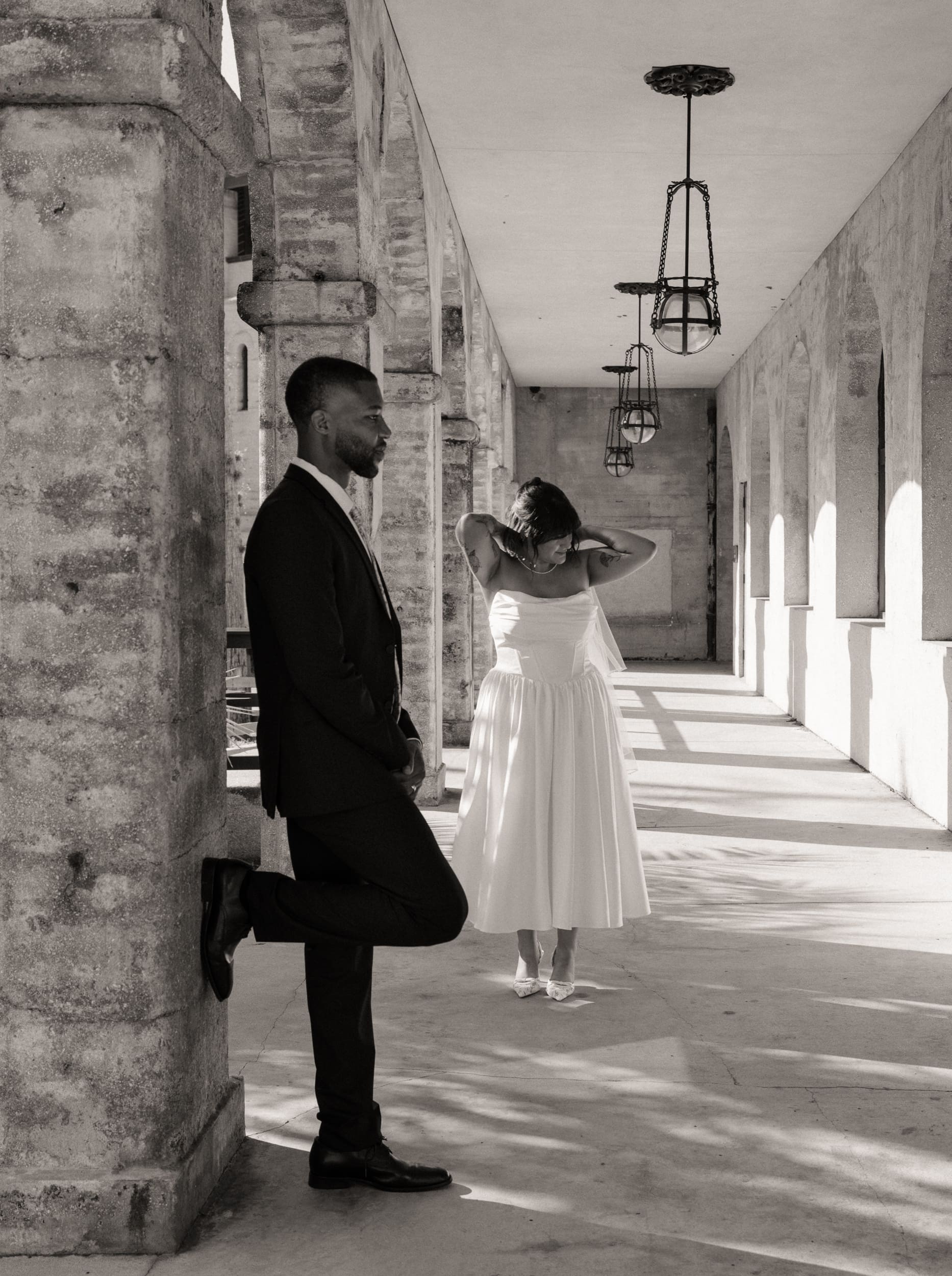 Couple framed by architectural arches at Lightner Museum courtyard elopement in St Augustine. 