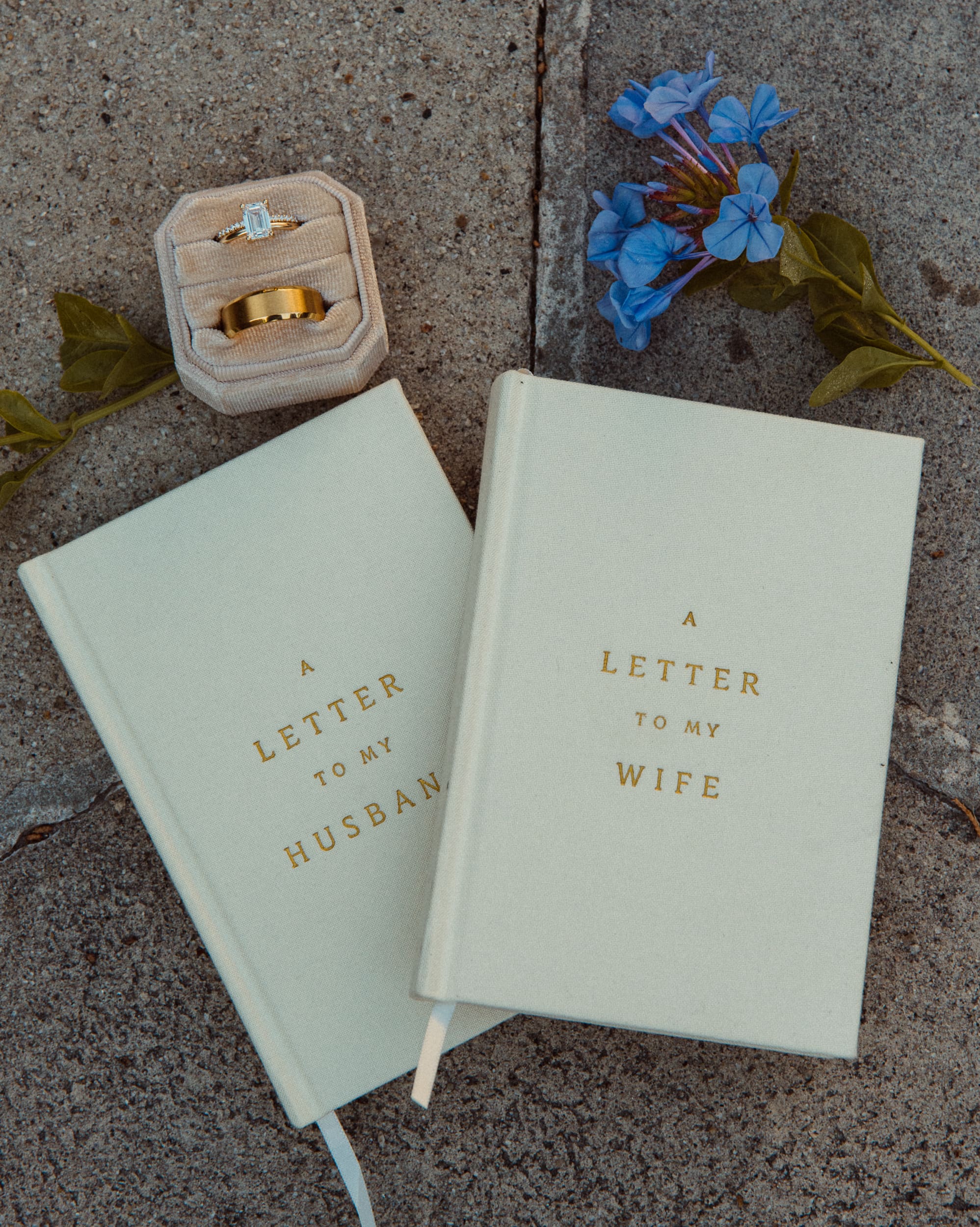 Elopement detail photo of wedding rings and vow books styled on stone surface at Vilano Beach.