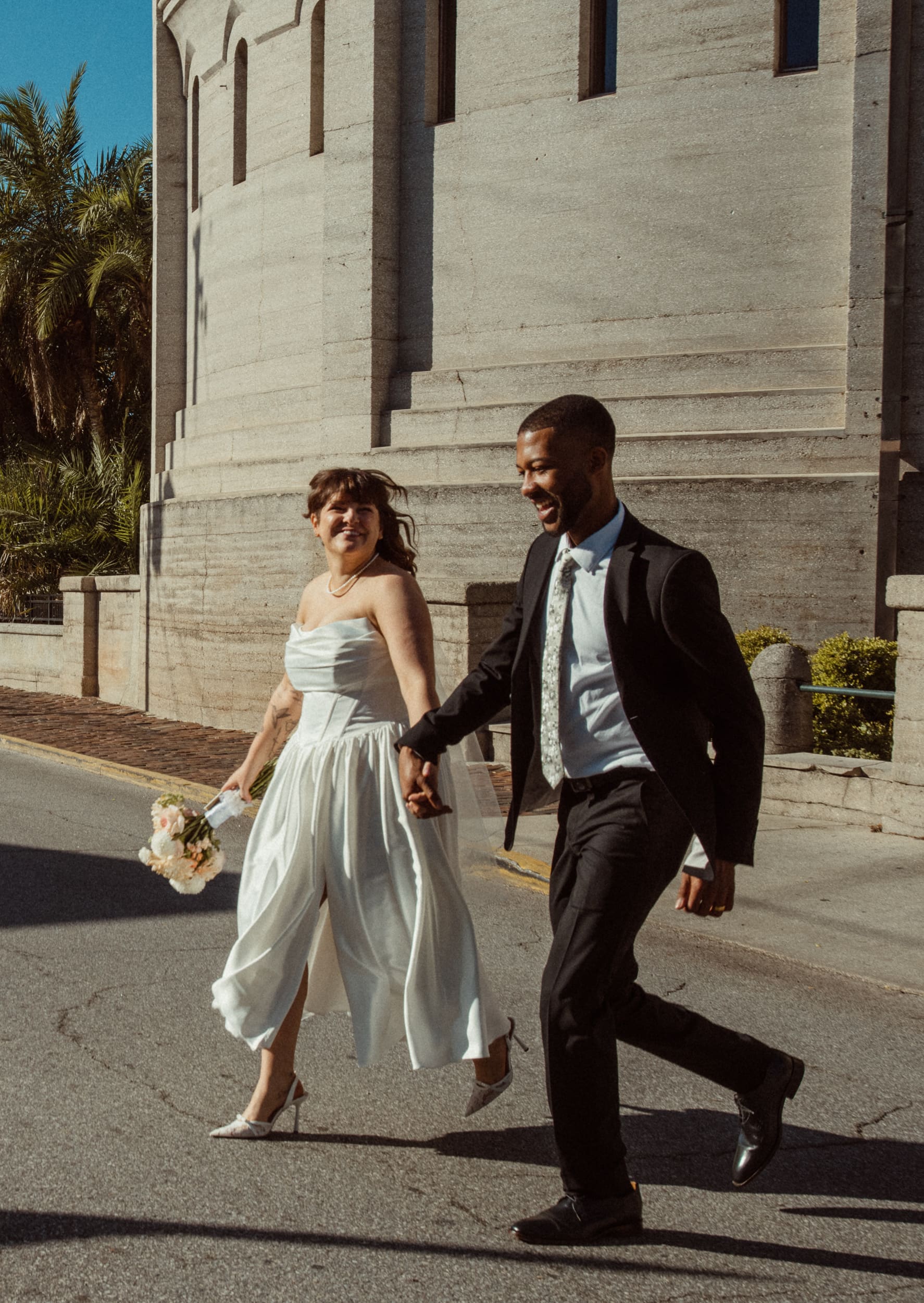 Couple walking through downtown St Augustine after Lightner Museum elopement. 