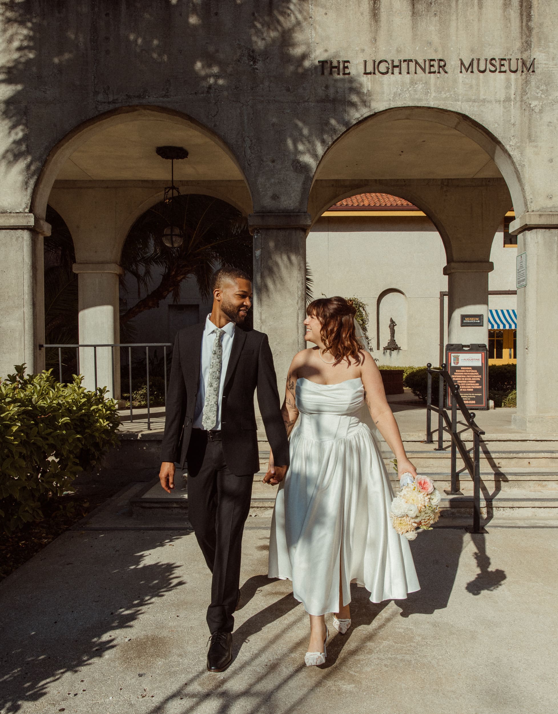 Couple walking together outside the Lightner Museum during their elopement in St. Augustine Florida. 