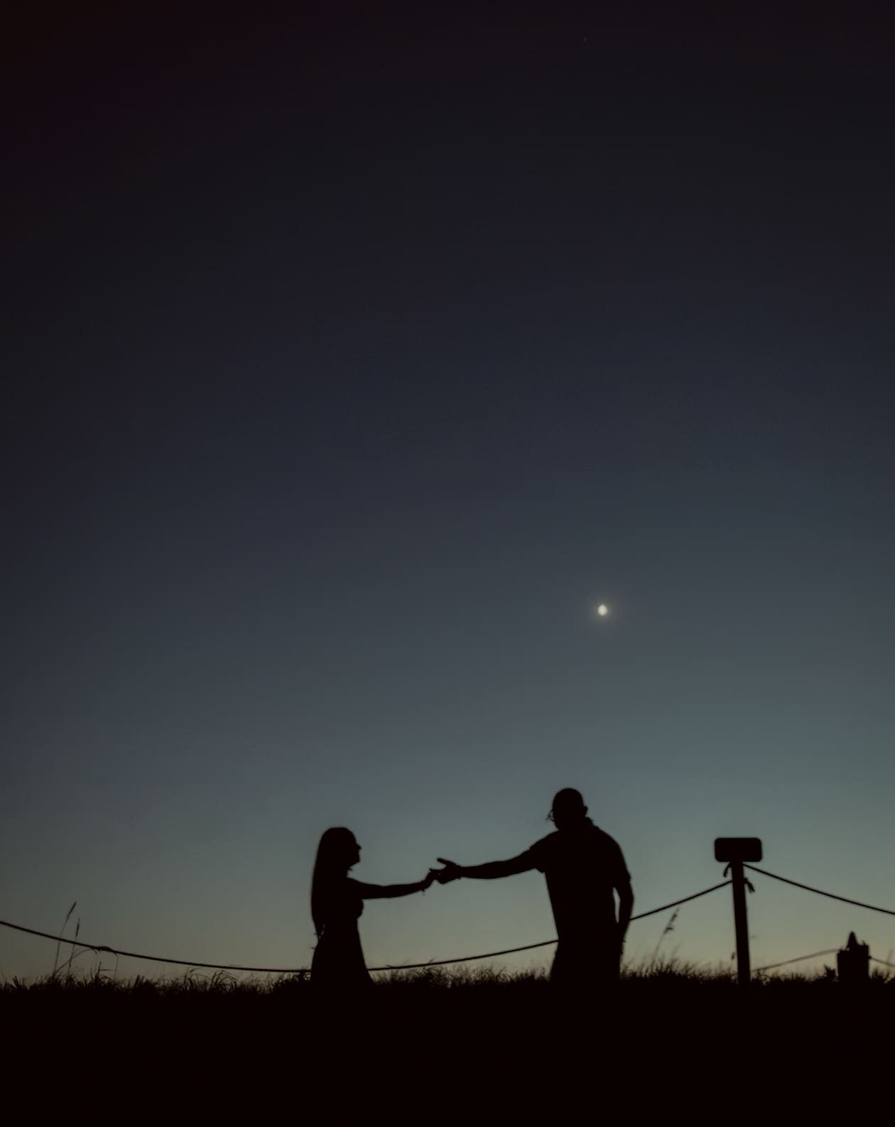 Silhouette portrait of wedding couple at Washington Oaks beach during sunrise ceremony. 
