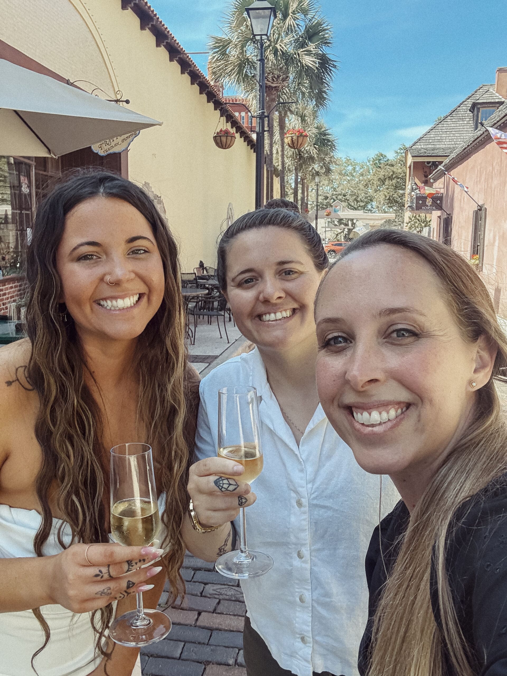 Couple celebrating their St. Augustine elopement with champagne on Aviles street with their wedding photographer, Brandi Denslow. 