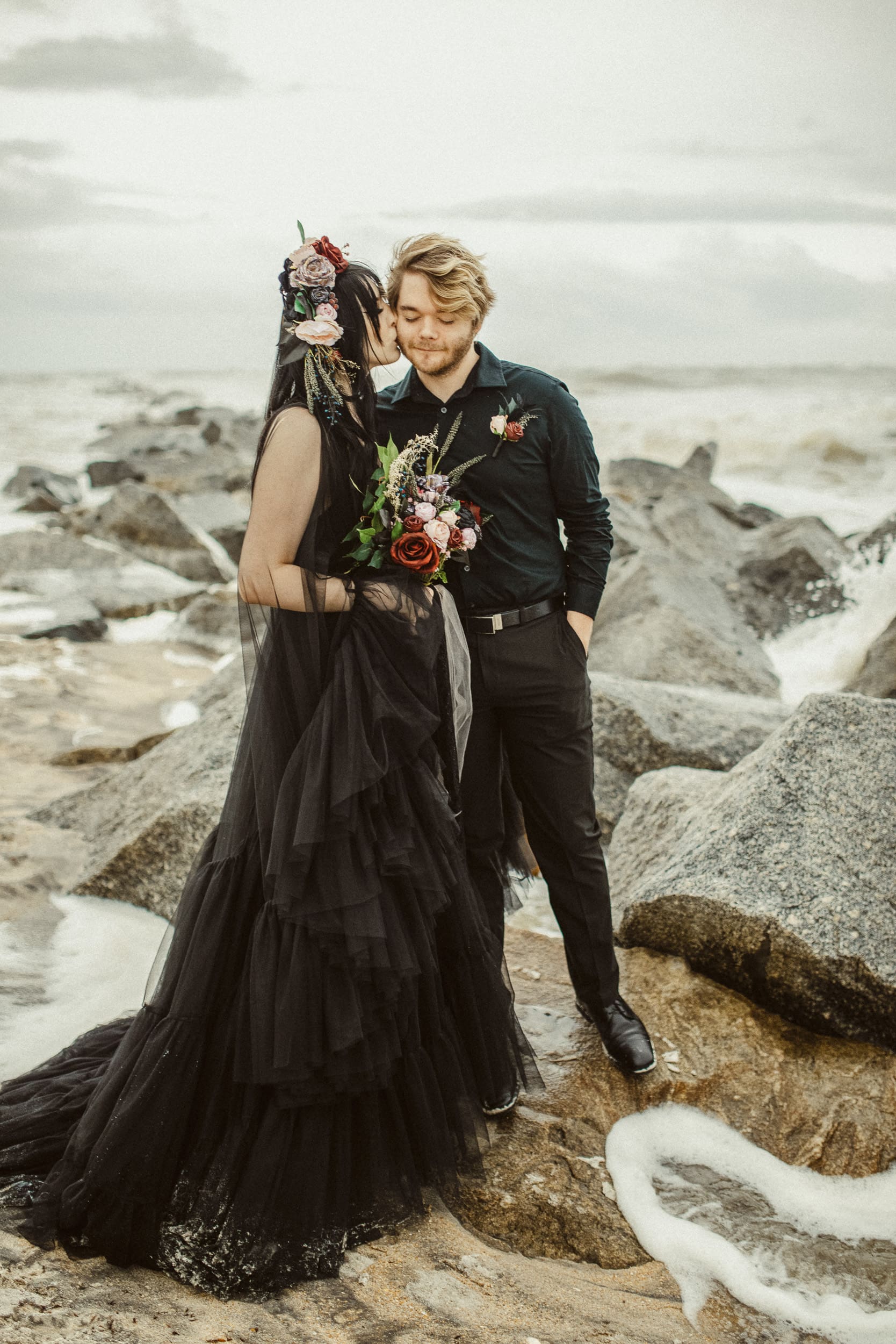 Editorial elopement portrait of couple on rocky shoreline near Vilano Beach.