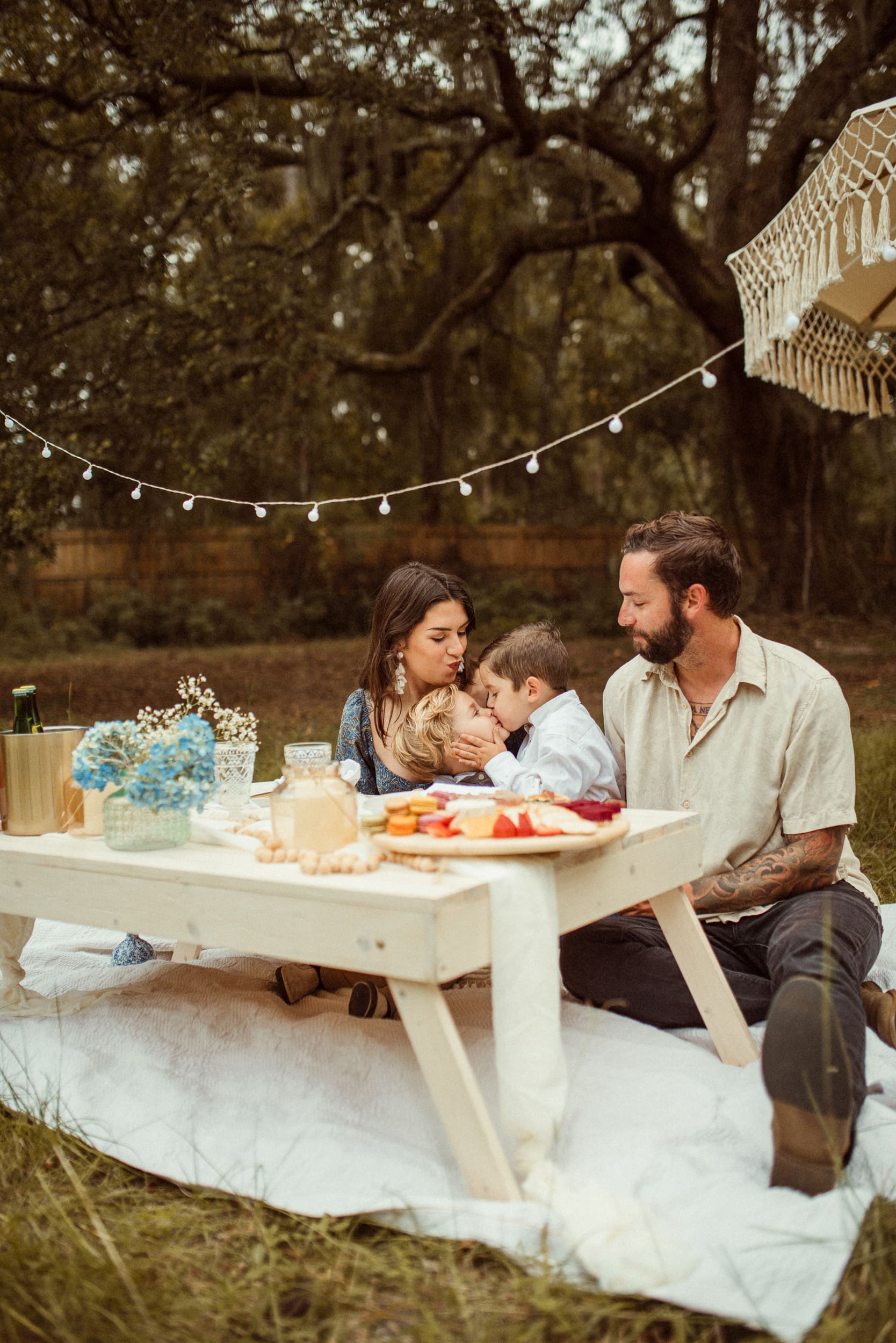 Family sitting together at a styled backyard picnic during an engagement session in Mandarin, Florida.