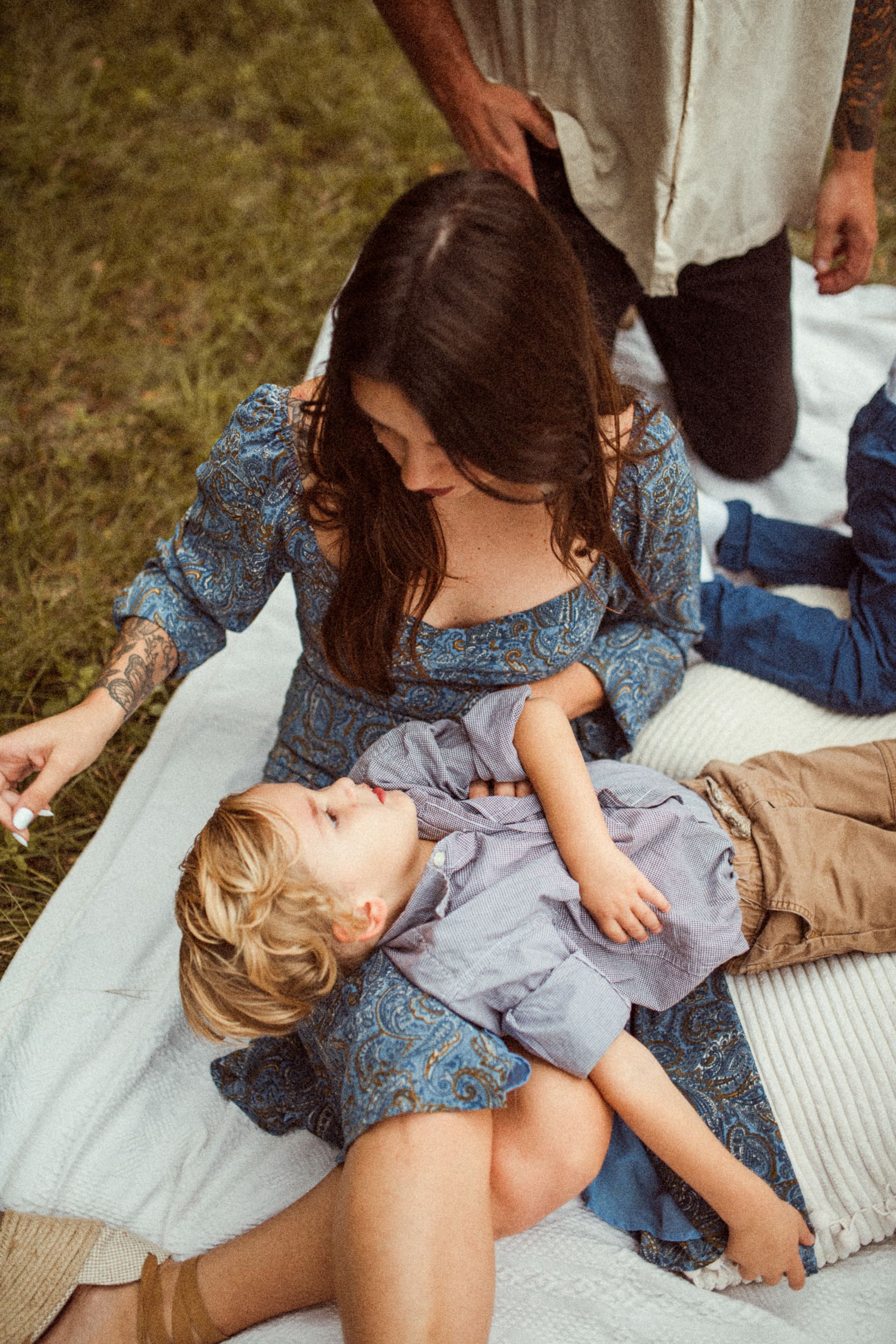 Mother holding her child on a blanket during an intimate backyard engagement session in Jacksonville, Florida.