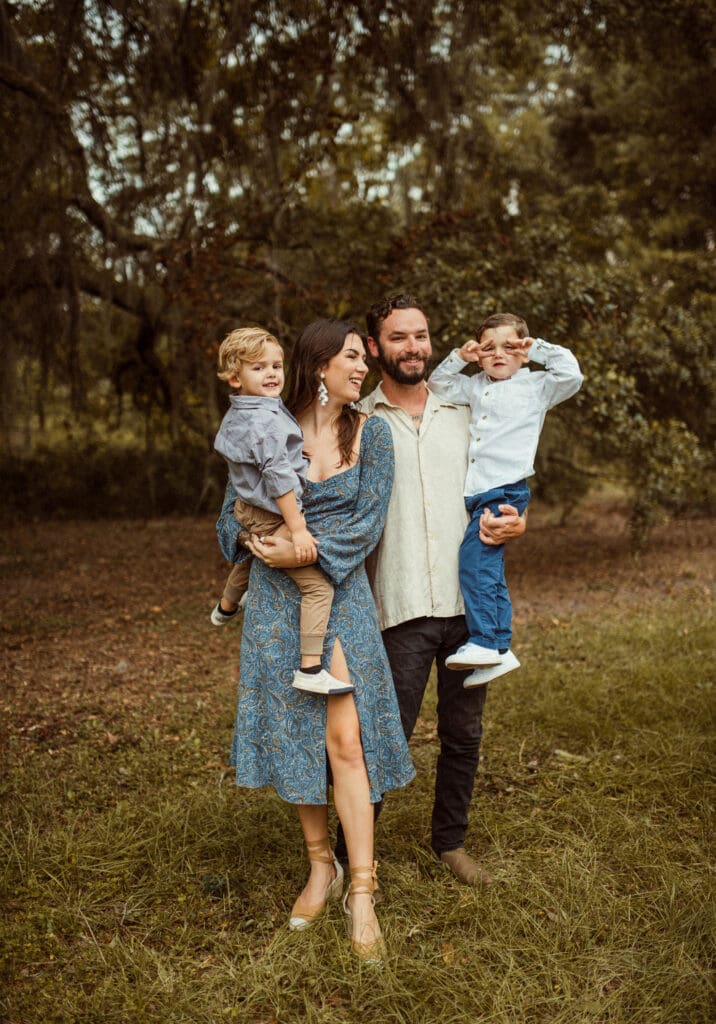 Couple walking through backyard with their children during intimate Mandarin engagement session.