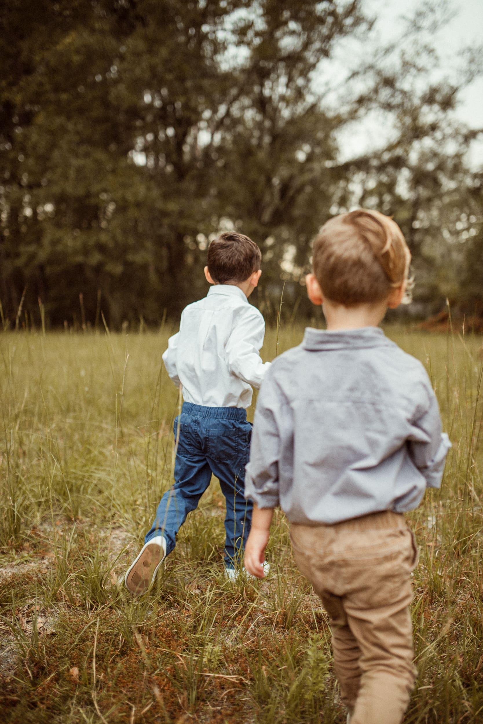 Children walking through grass during relaxed backyard engagement session in Jacksonville.