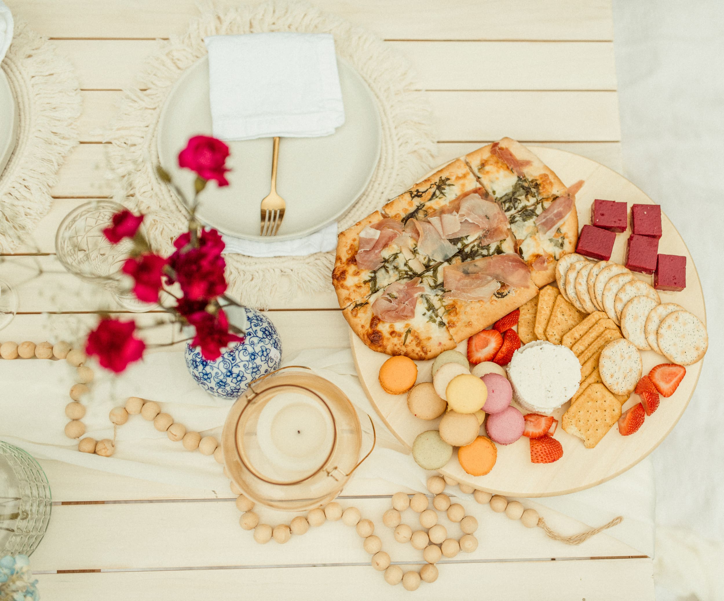 Close up of picnic table with bread, fruit, and styling details during backyard engagement session.