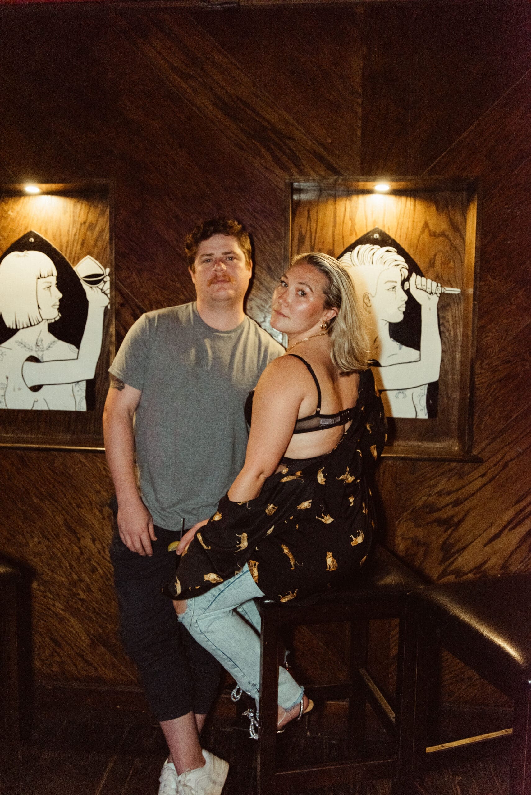 Playful couple portrait photographed with intentional posing during a nightlife-inspired session. 