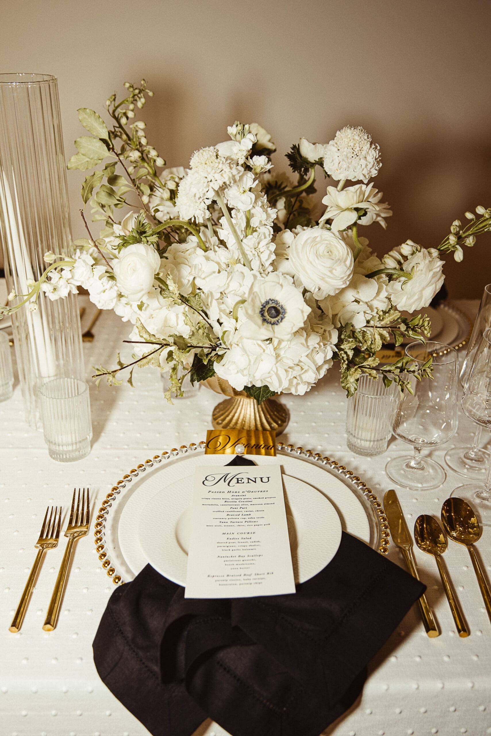 Luxury wedding reception tablescape with white florals and gold details, photographed by St. Augustine wedding photographer Brandi Denslow. 