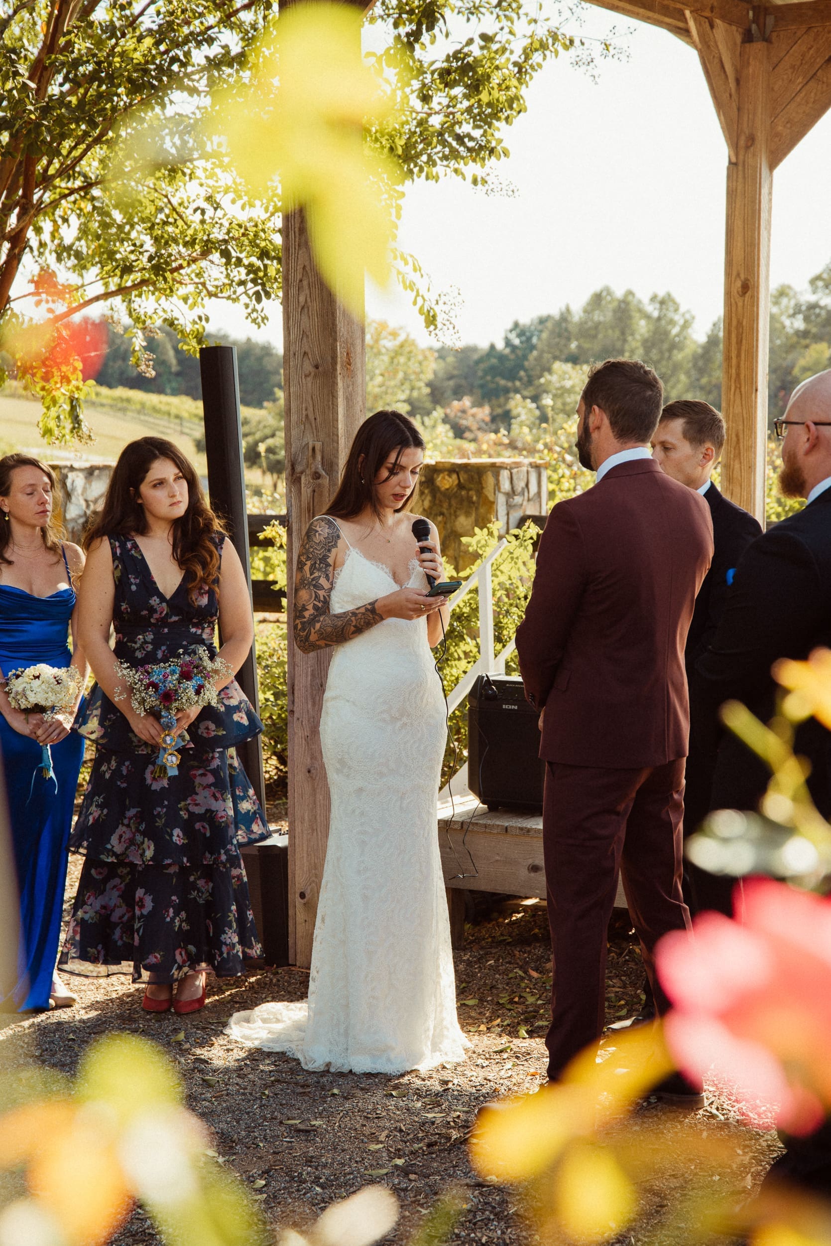 Bride reading wedding vows under rustic pergola in private garden at Parker-Binns Vineyard in North Carolina. 