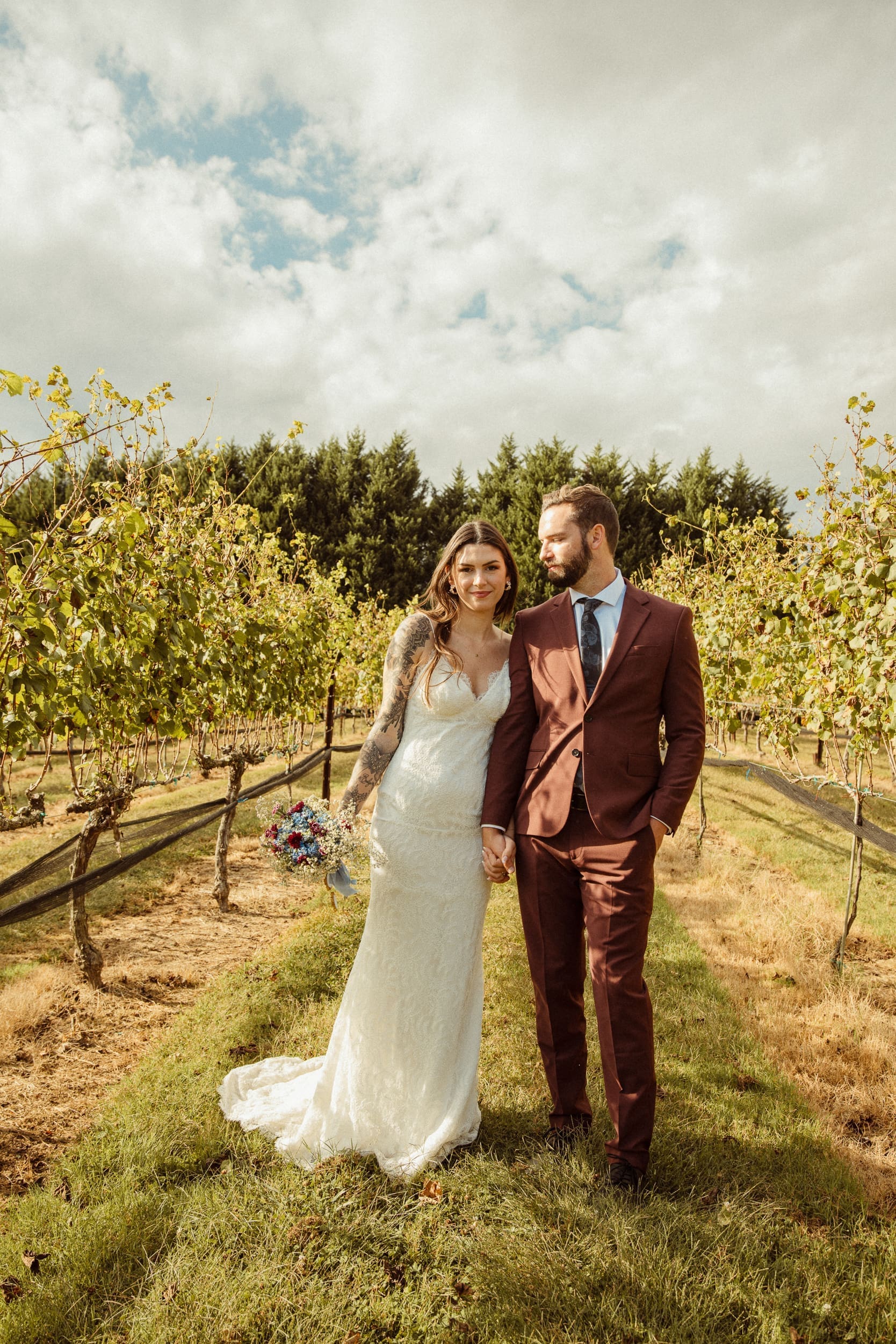 Bride and groom standing in vineyard rows at Parker-Binns Vineyard North Carolina, destination photography by Brandi Denslow