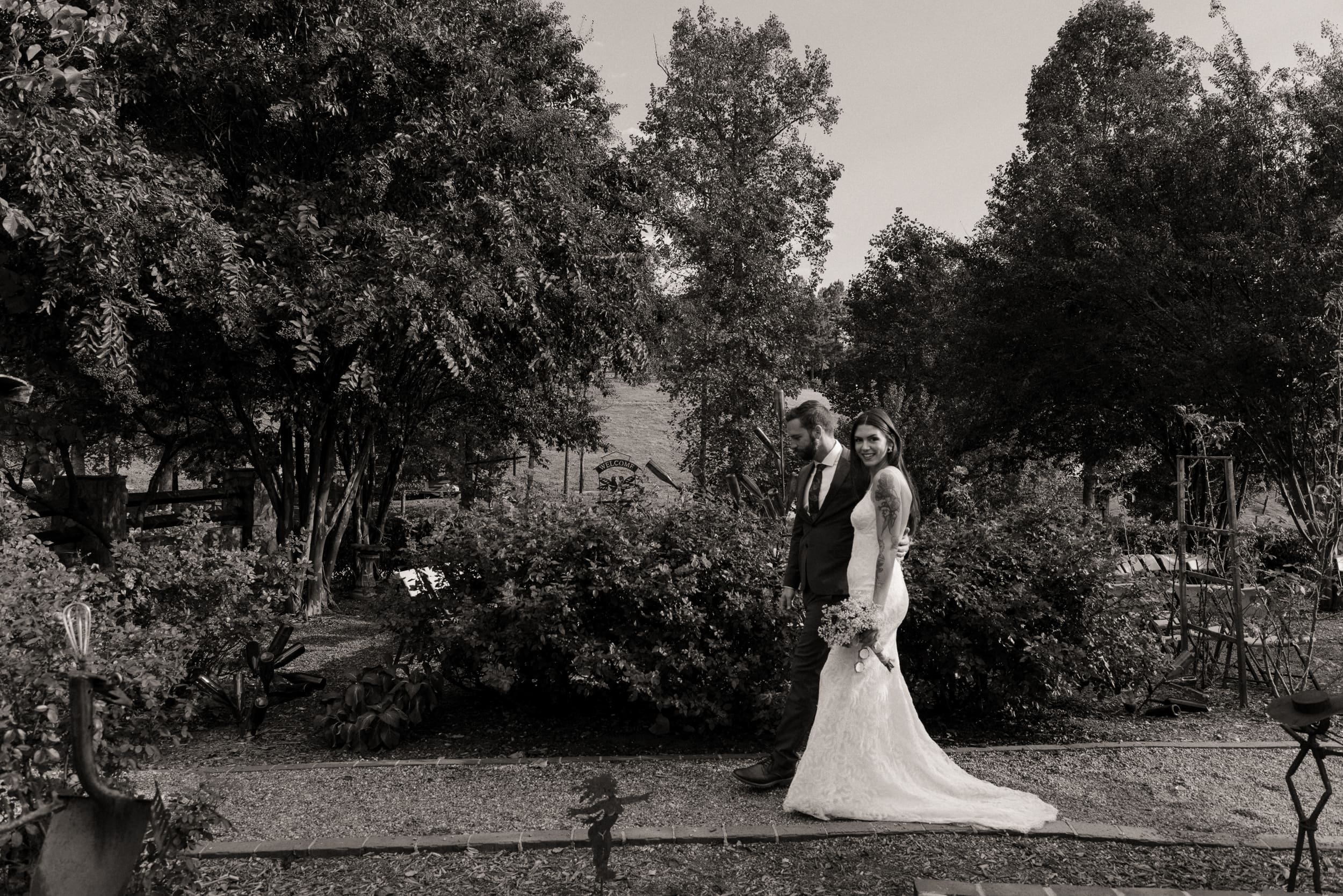 Black and white wide portrait of bride and groom in vineyard garden at Parker-Binns North Carolina. 