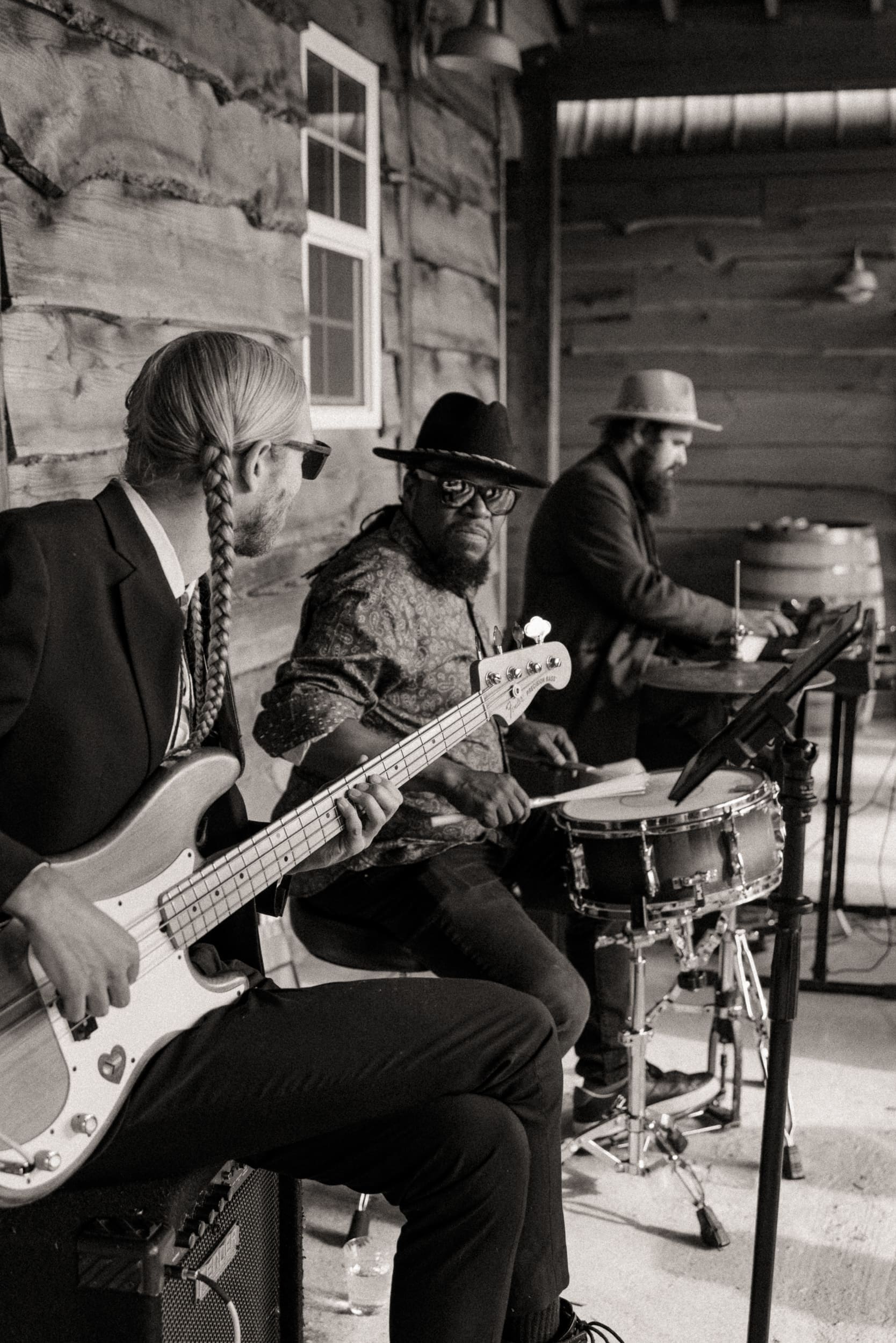 Black and white photo of a live band performing during wedding reception inside rustic pavilion at vineyard in North Carolina