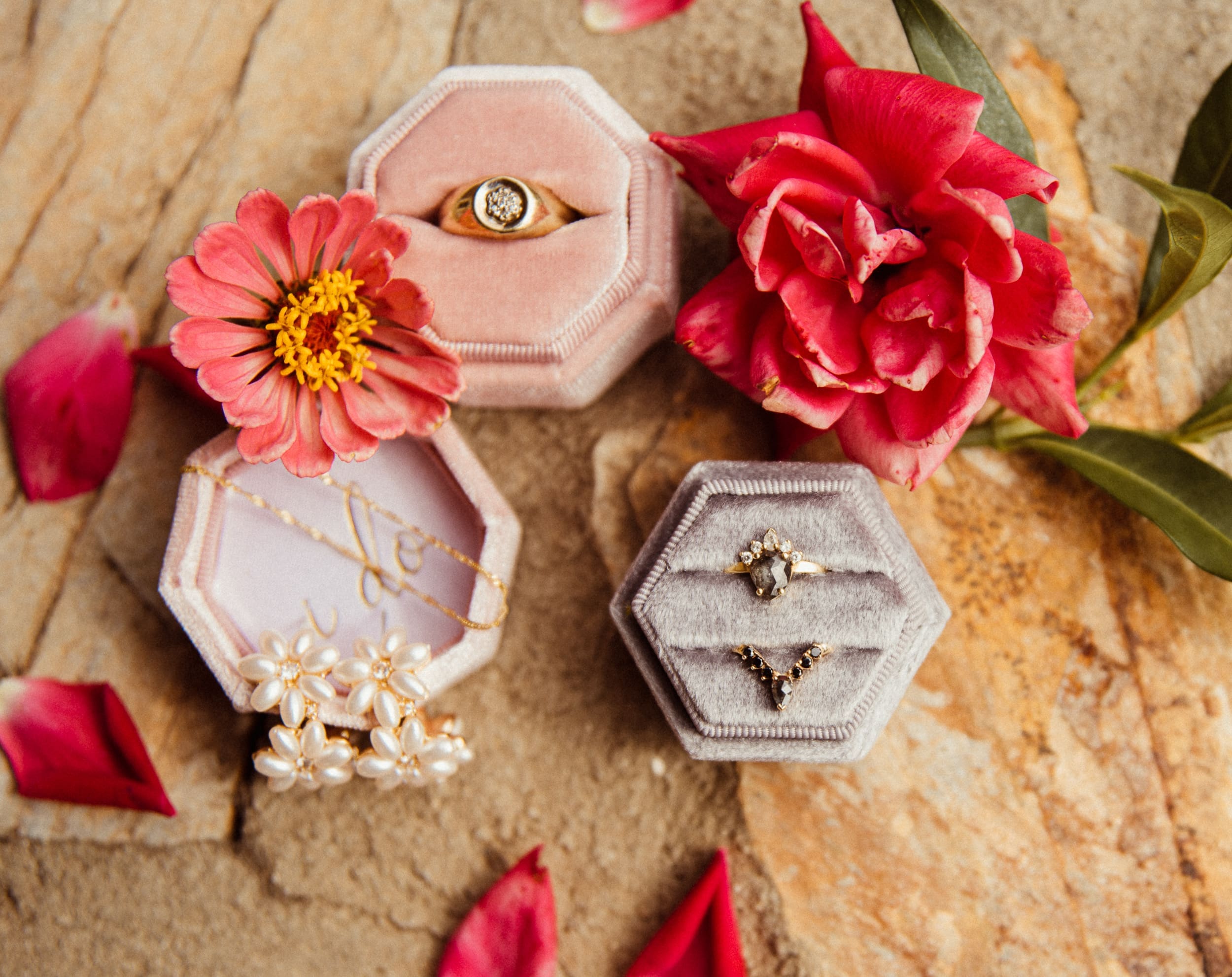 Wedding ring detail show with velvet ring boxes and pink roses at Parker-Binns Vineyard North Carolina.