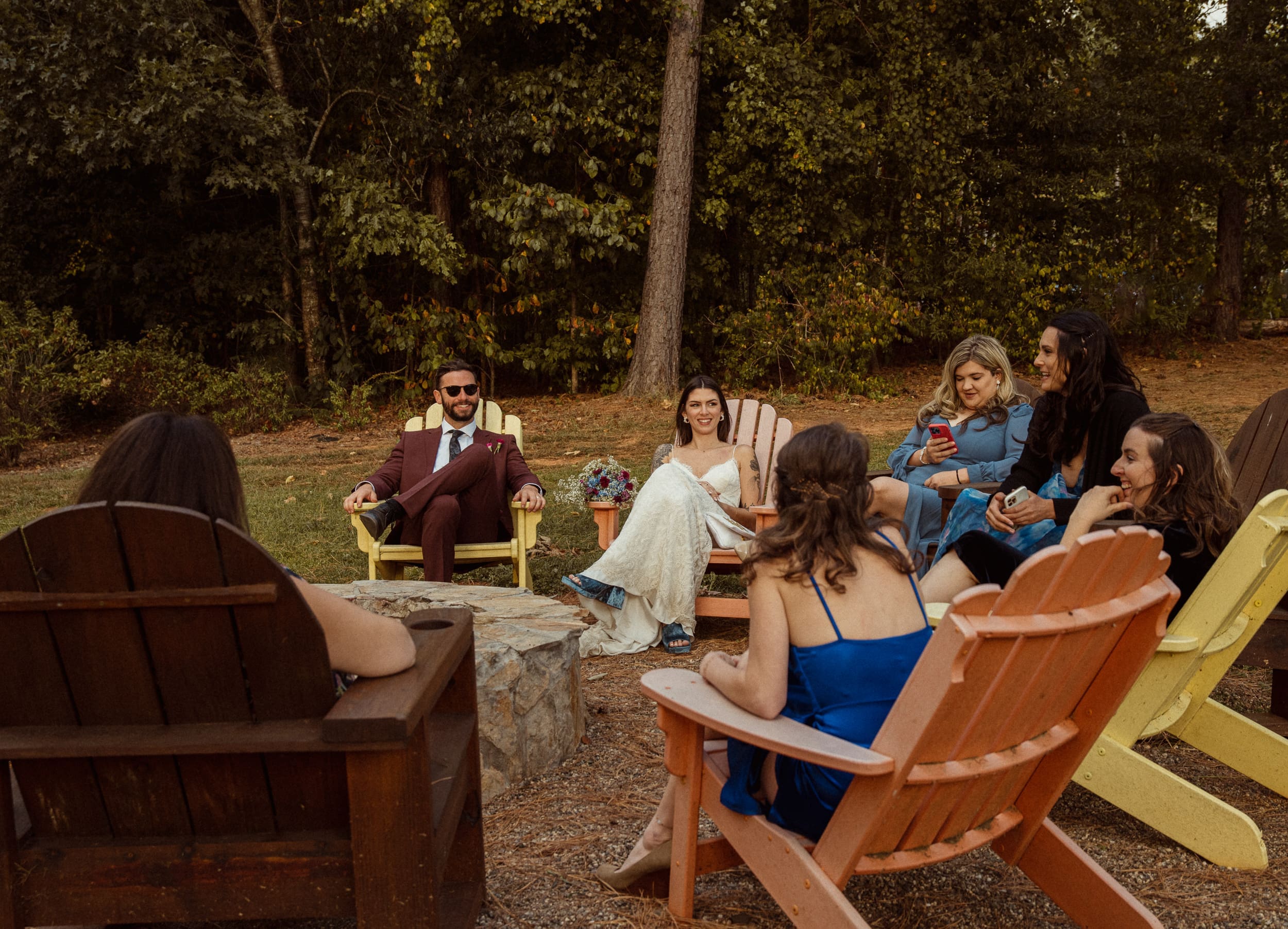 Wedding party relaxing in colorful Adirondack chairs during evening wedding reception at Parker-Binns Vineyard, North Carolina. 