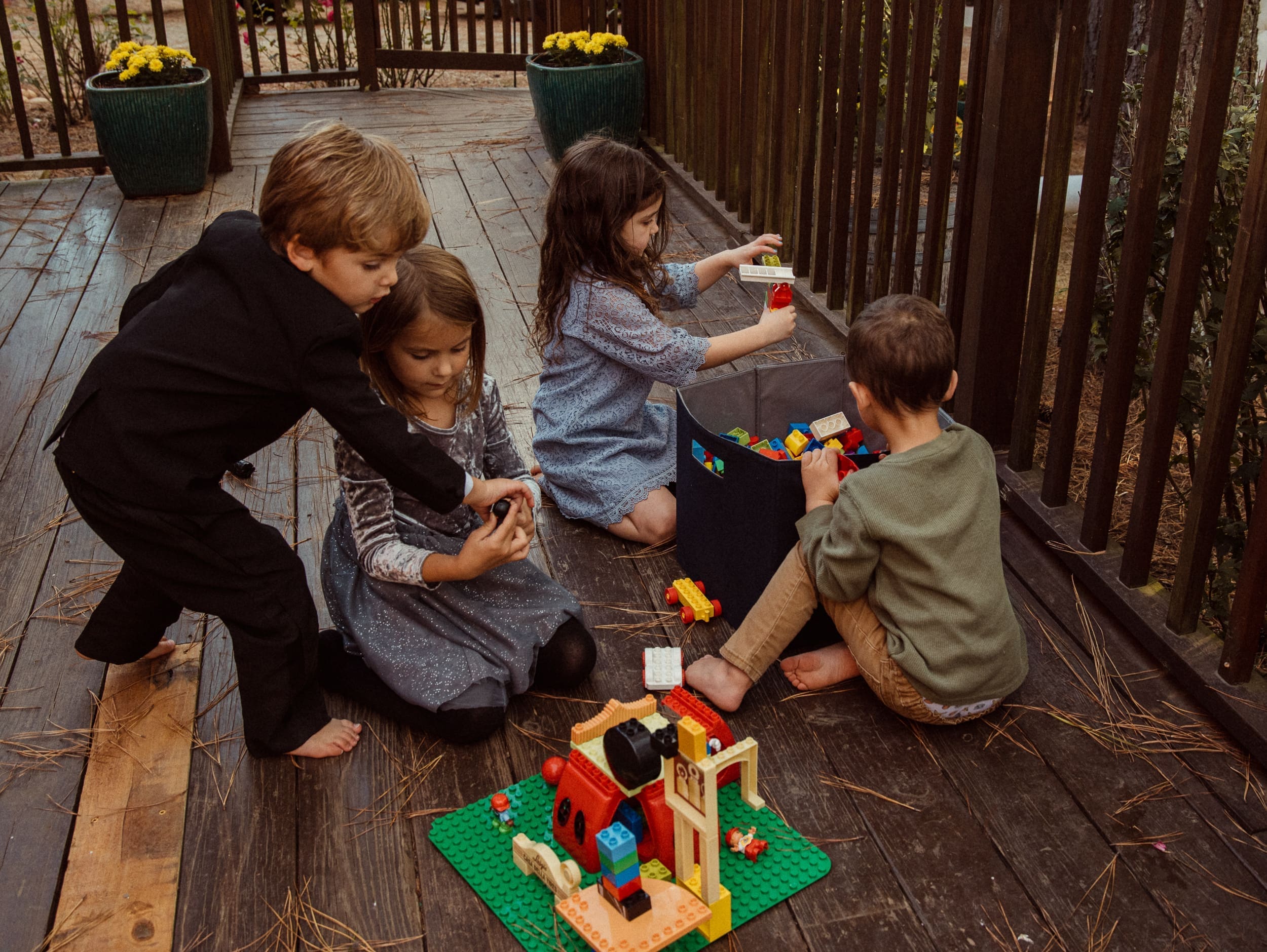 Children playing with legos on a large porch during an evening reception at Parker-Binns Vineyard in North Carolina. 