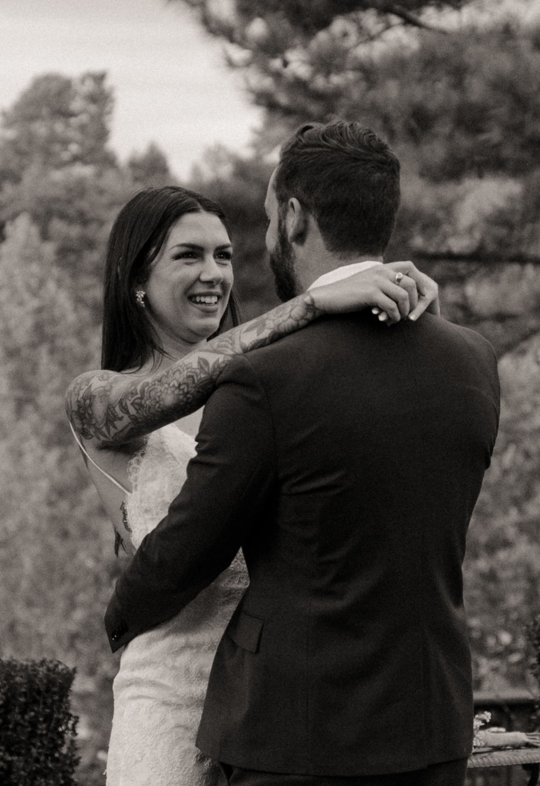 Black and white photo of bride laughing with arms around groom at Parker-Binns Vineyard North Carolina. 