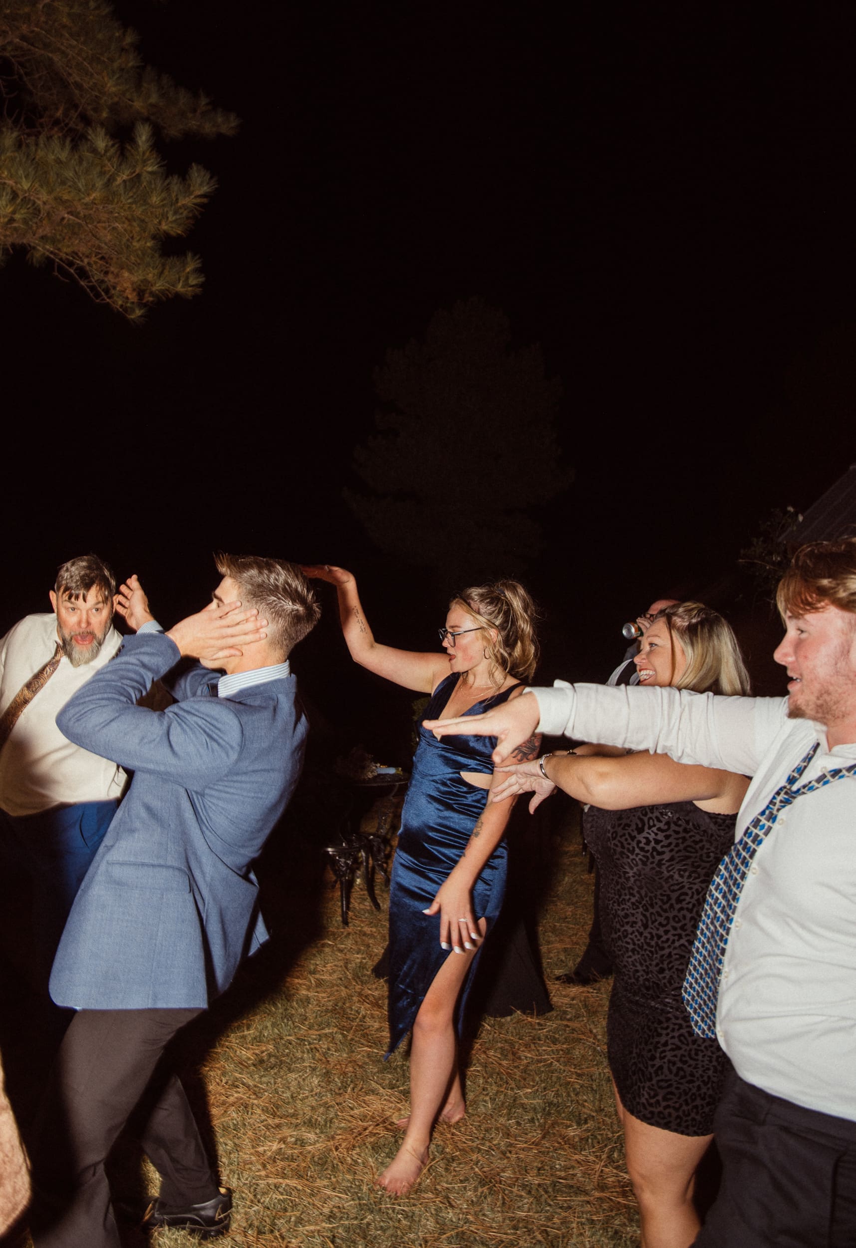 Guests dancing and celebrating at outdoor wedding reception, candid wedding photography by Brandi Denslow. 
