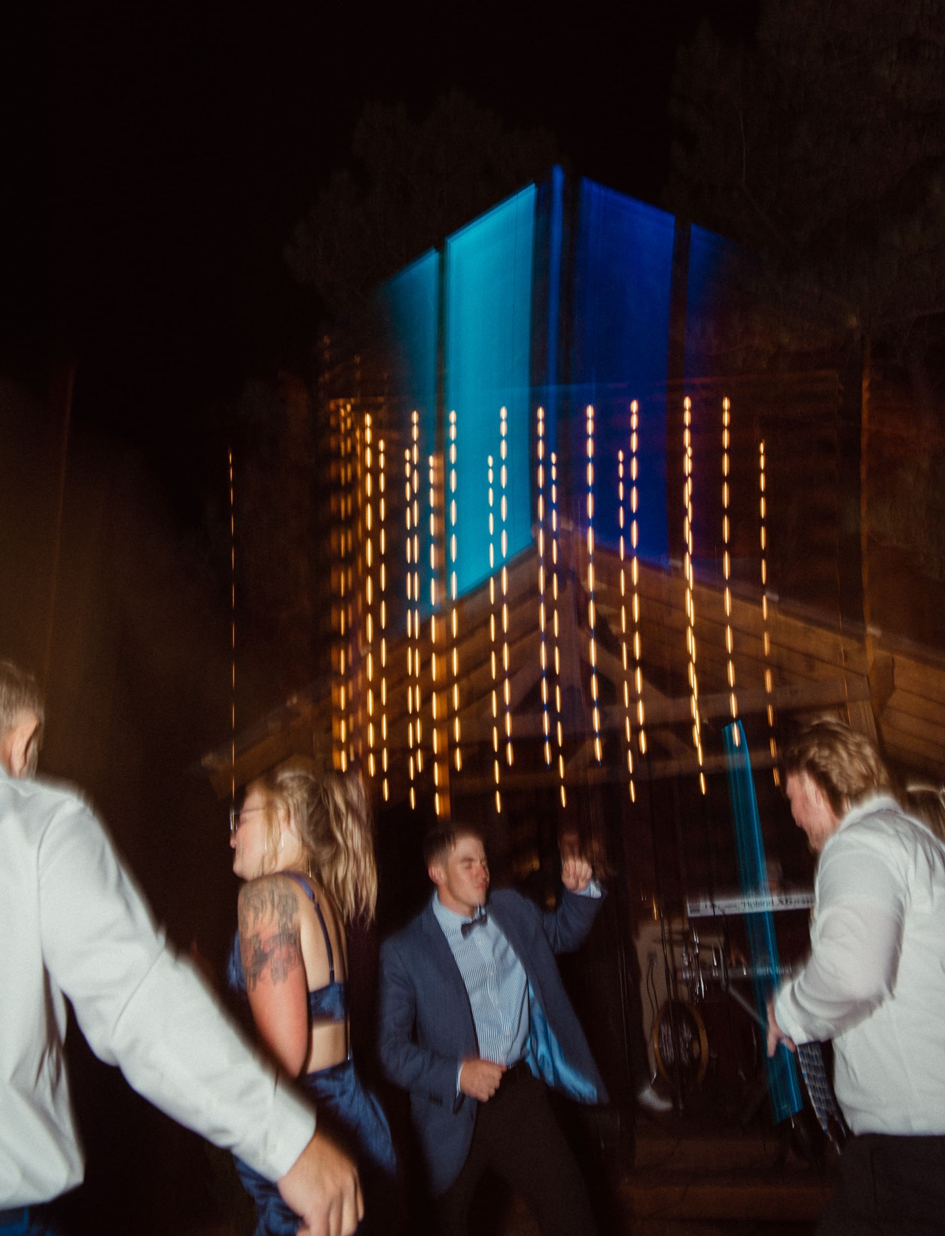Guests dancing under dramatic blue and amber stage lighting during evening reception at Parker-Binns Vineyard North Carolina, Brandi Denslow Photography. 