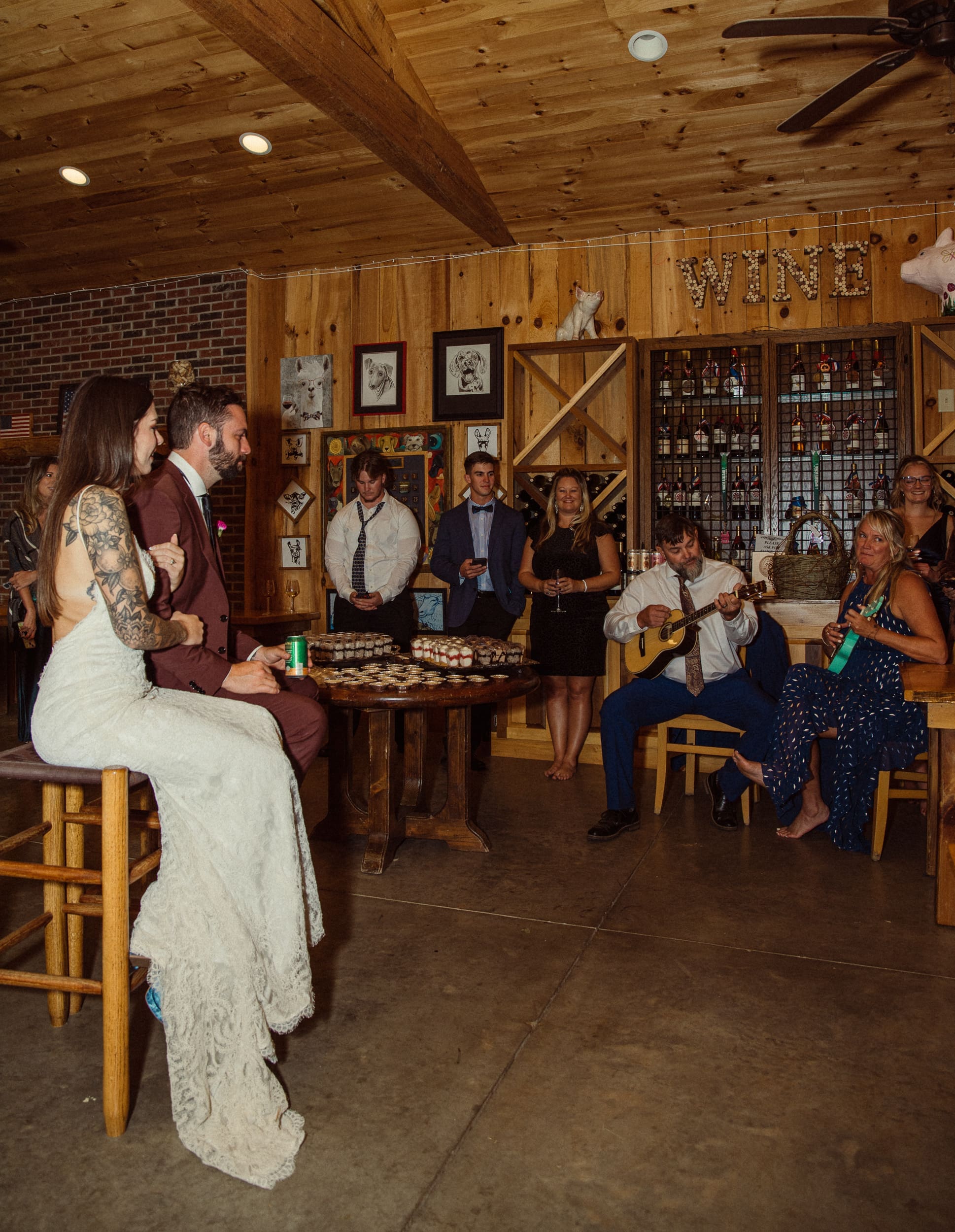 Bride and groom surprised by family ukulele serenade inside Parker-Binns Vineyard wine room, the emotional highlight of the wedding night, photographed by Brandi Denslow. 