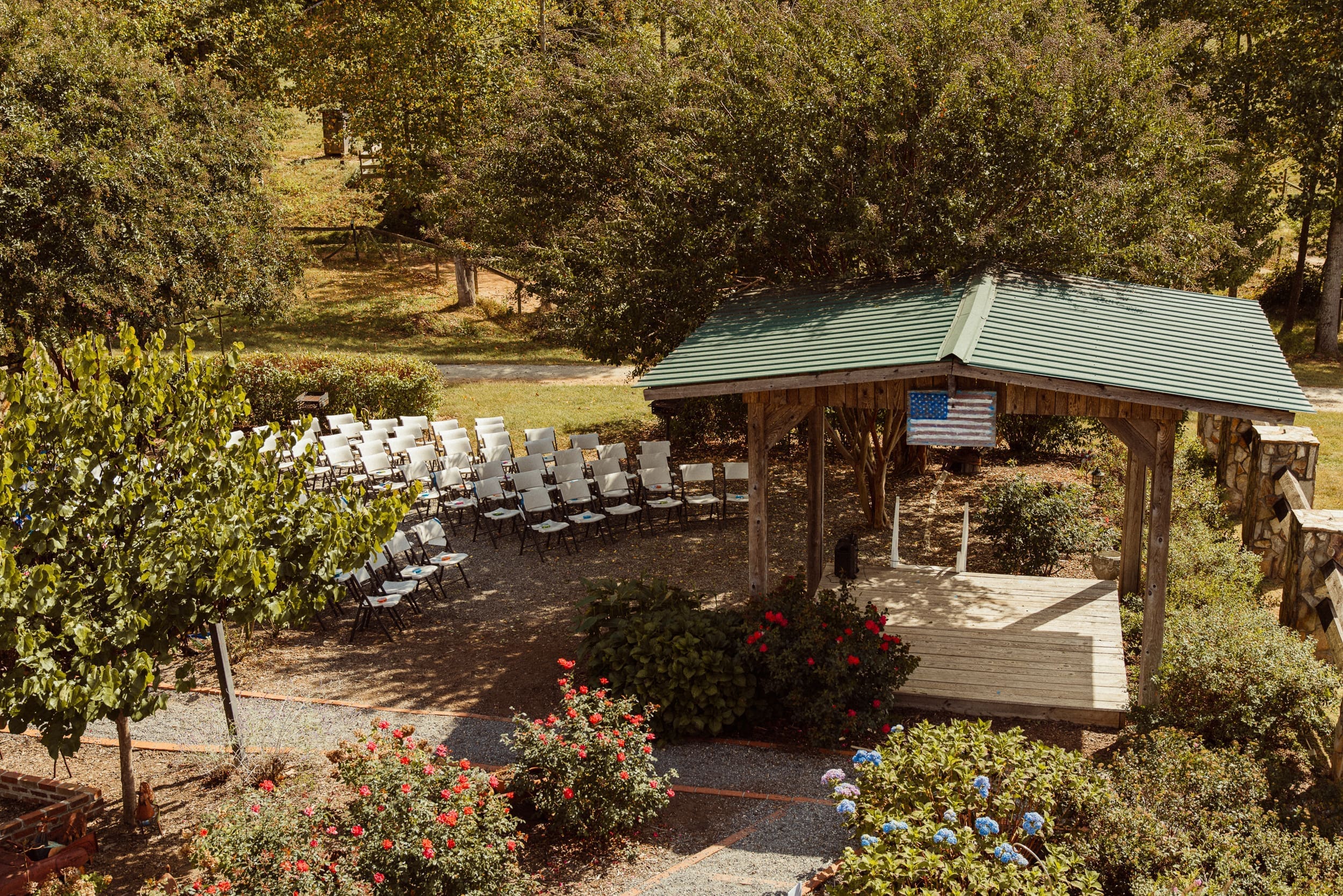 Outdoor wedding ceremony setup with white chairs and rustic pavilion at Parker-Binns Vineyard North Carolina.