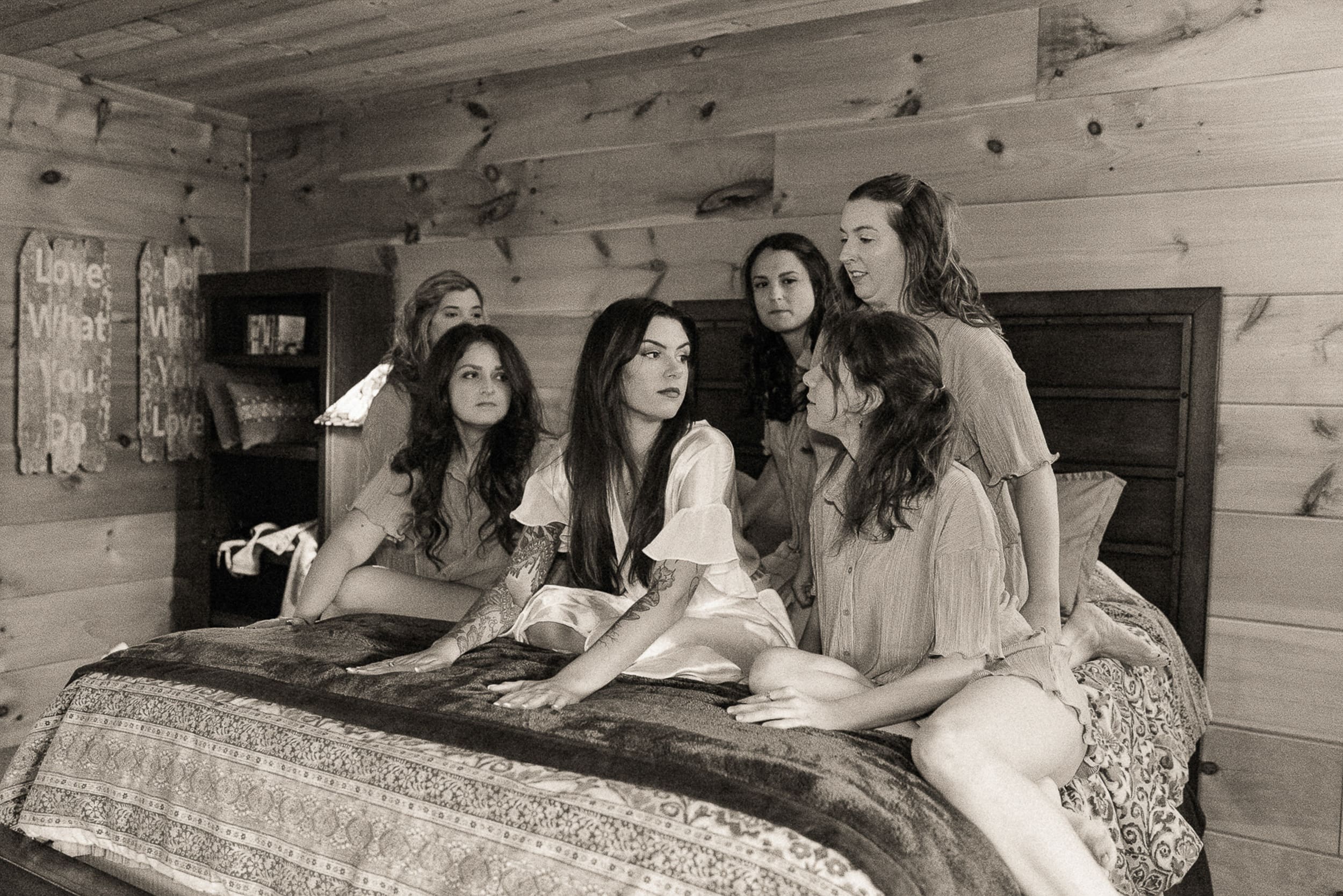 Black and white photo of bride surrounded by bridesmaids getting ready inside the chateau at Parker-Binns Vineyard North Carolina. 