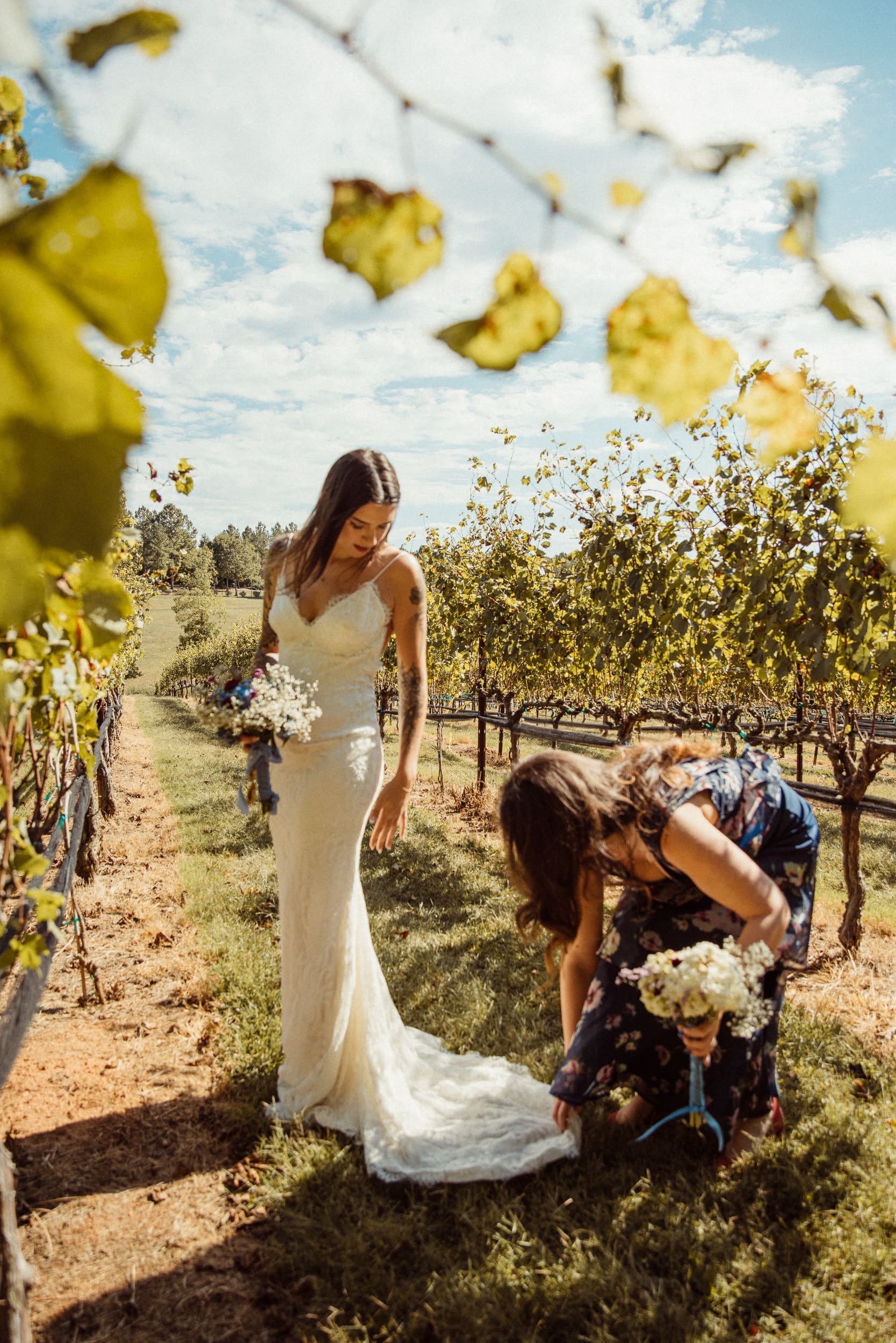 Bride standing in vineyard rows surrounded by falling autumn leaves at Parker-Binns Vineyard North Carolina, destination wedding photography by Brandi Denslow. 