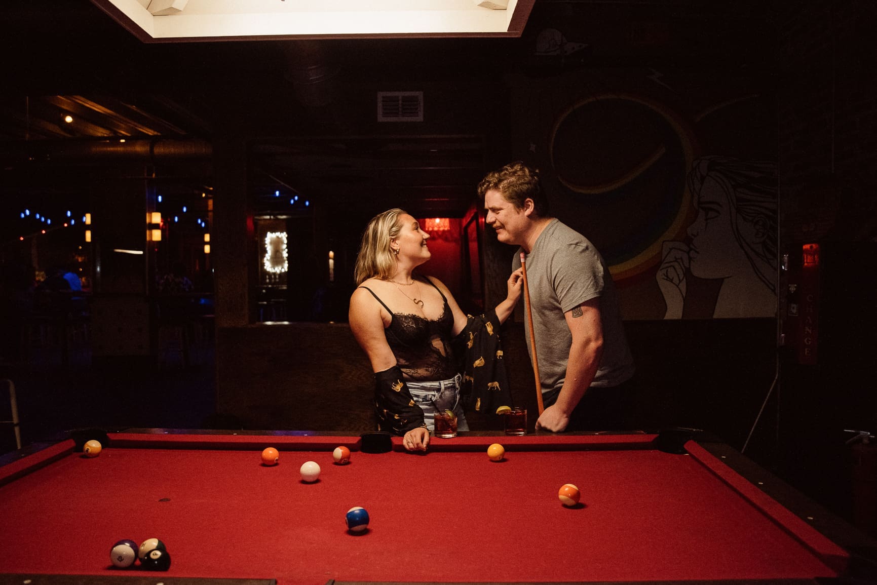 Couple sharing and intimate moment during moody bar engagement session in St. Augustine, photography by Brandi Denslow.