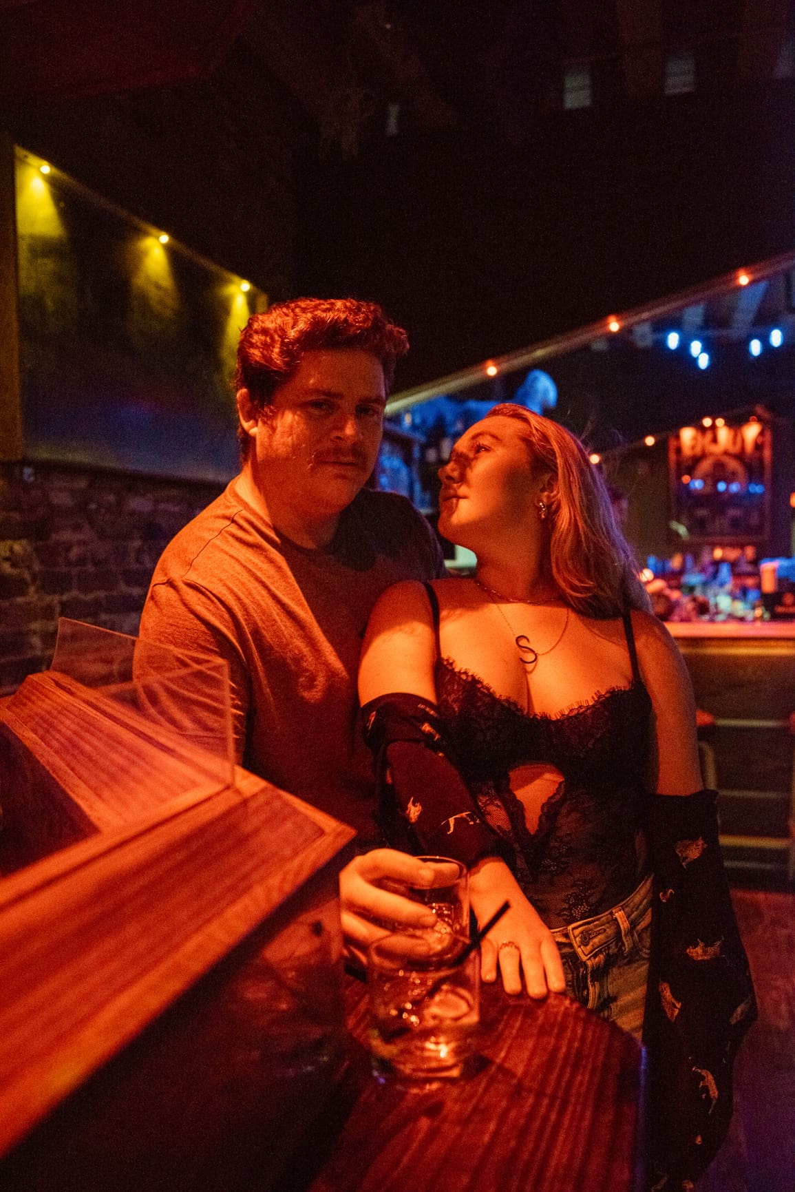 Couple during a cinematic night engagement session at an outdoor bar in St. Augustine, Florida.