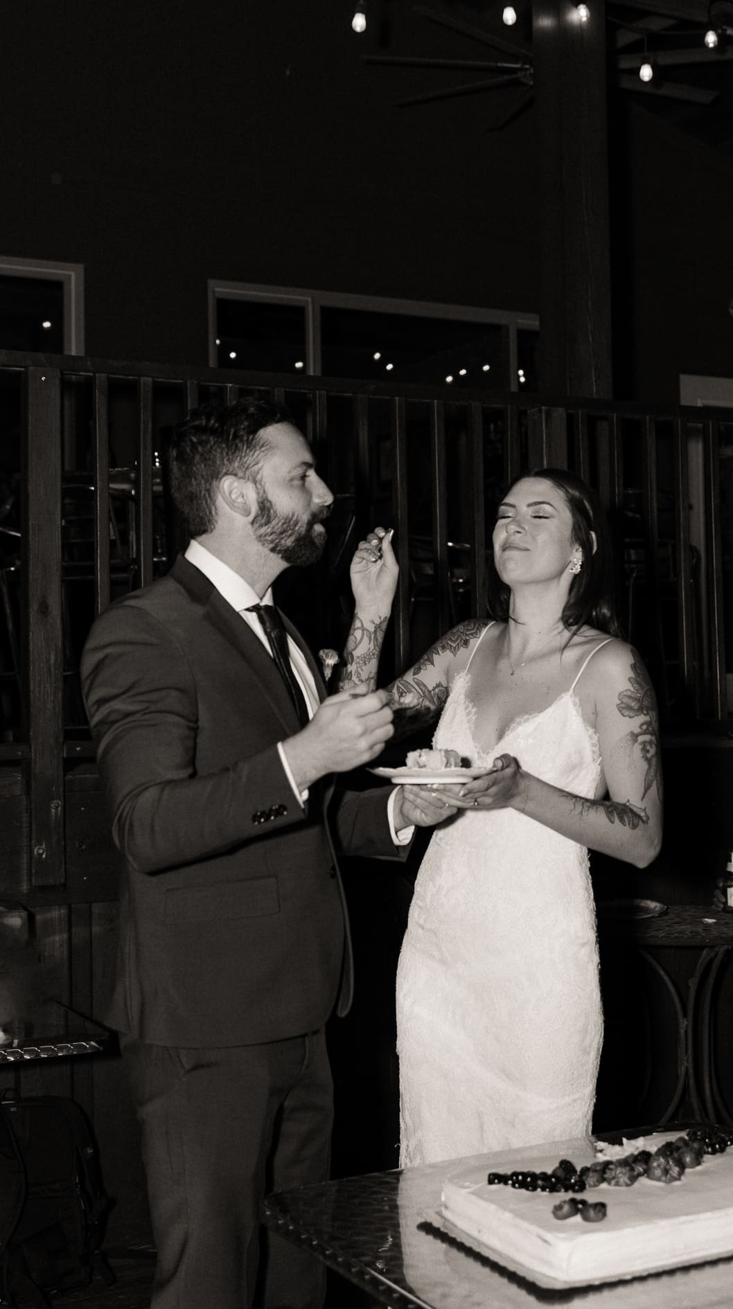 Black and white cake cutting moment at evening wedding photographer Brandi Denslow.