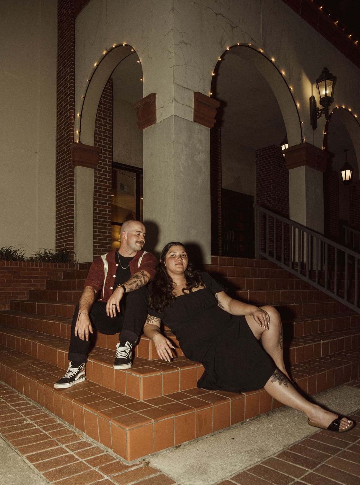 Couple posed on historic brick steps at night during a downtown St. Augustine engagement session. 