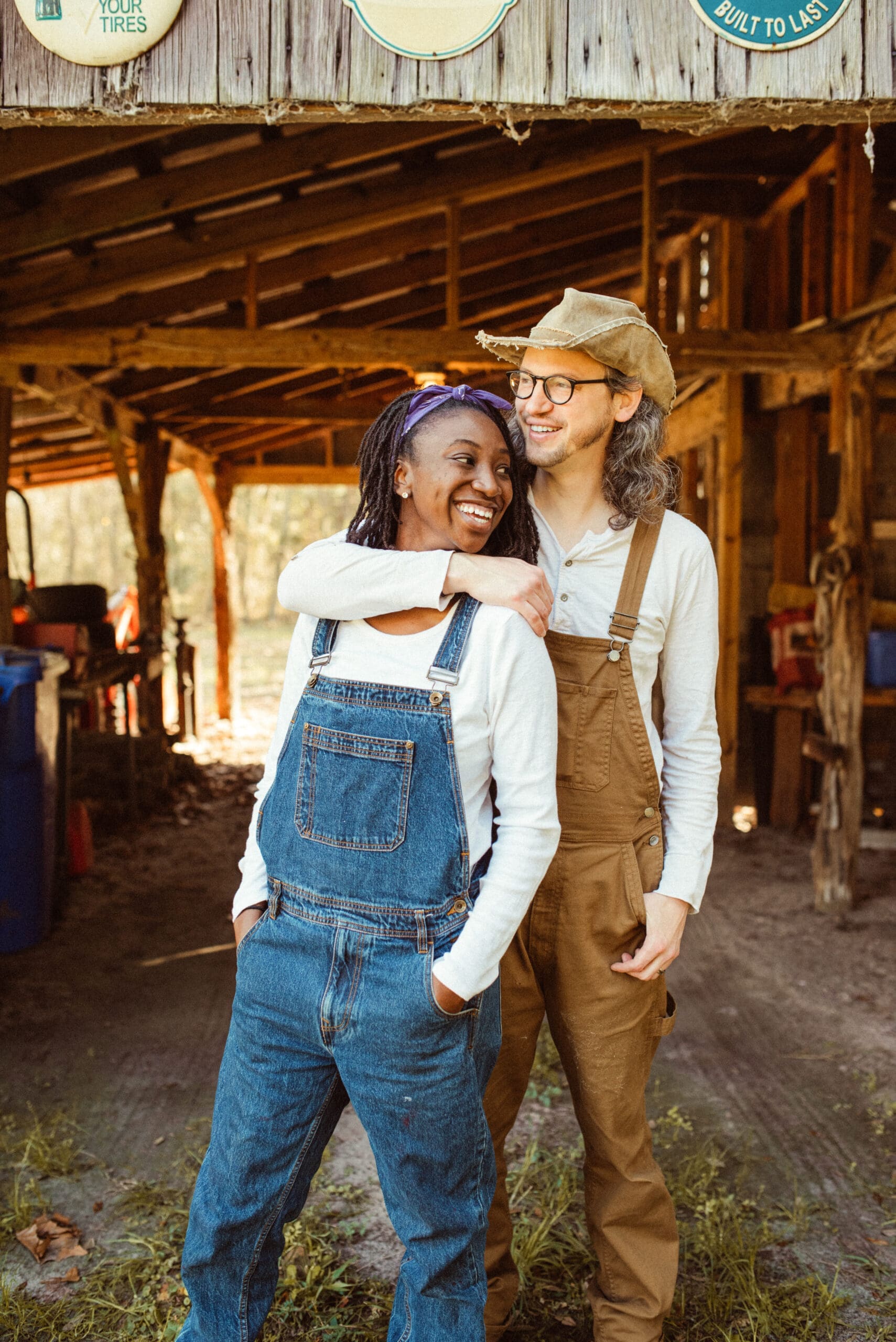 Couple laughing together inside a rustic barn during a natural engagement session in Florida. 