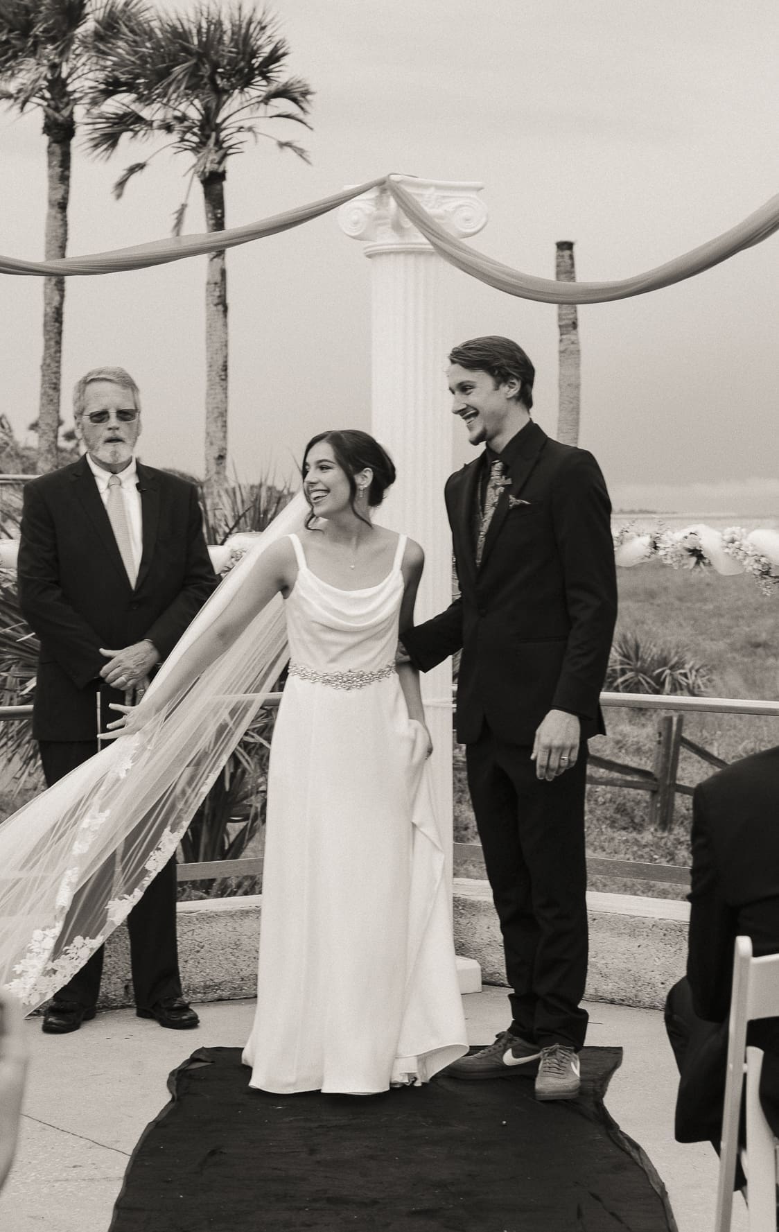Bride and groom laugh together during their wedding ceremony. 