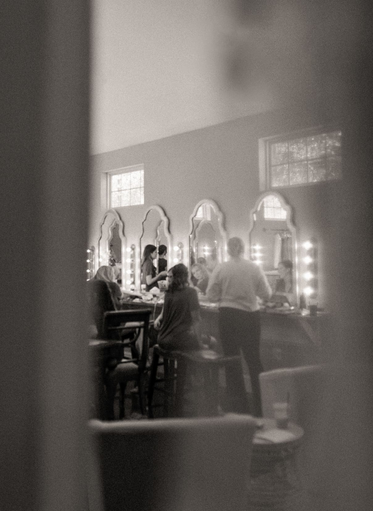 Hair and makeup artists prepare the bridal party on the wedding morning. 