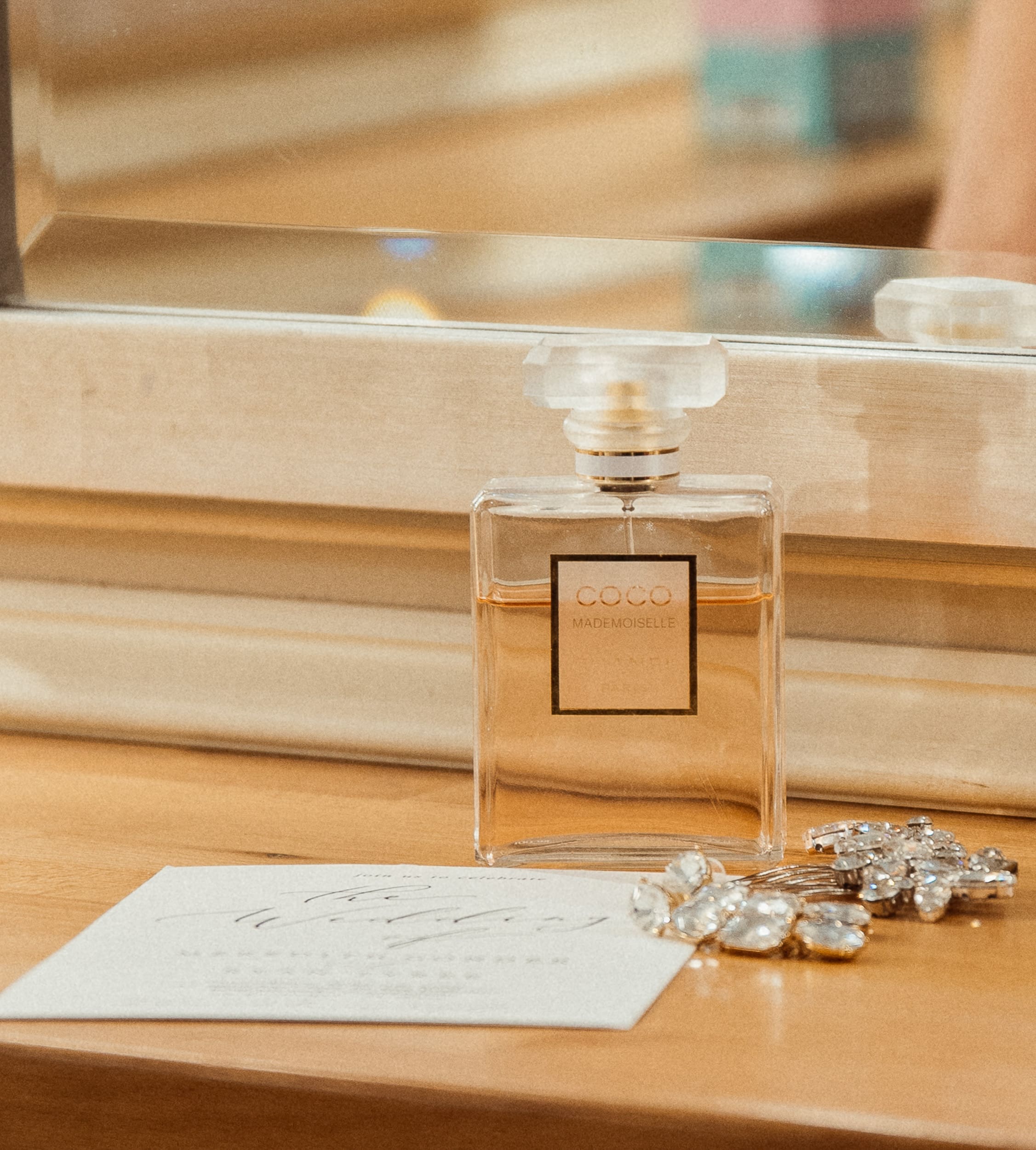 Wedding perfume bottle and bridal jewelry photographed during getting-ready moments.