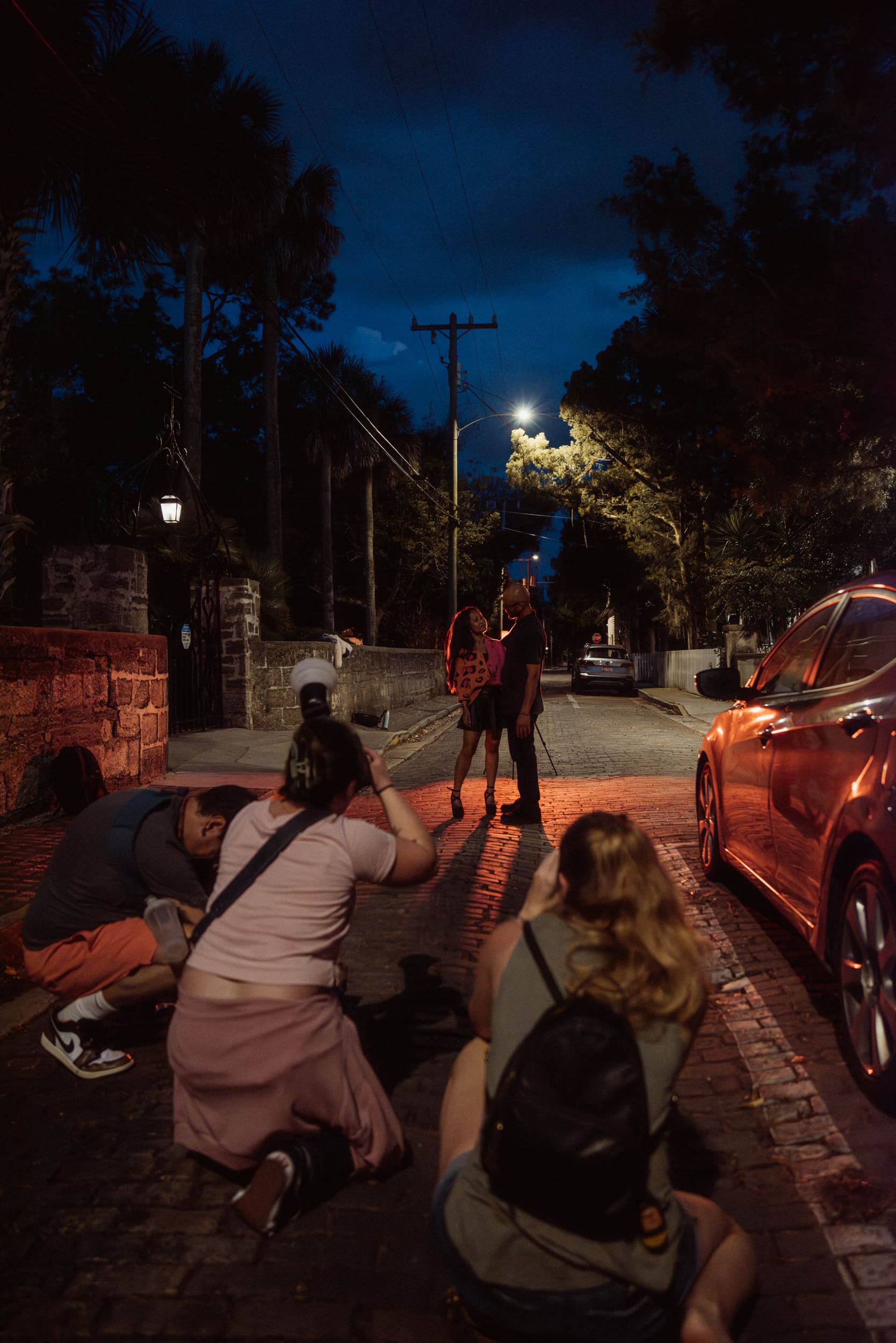 Couple embracing at night during a St. Augustine photography workshop, lit by warm street lighting