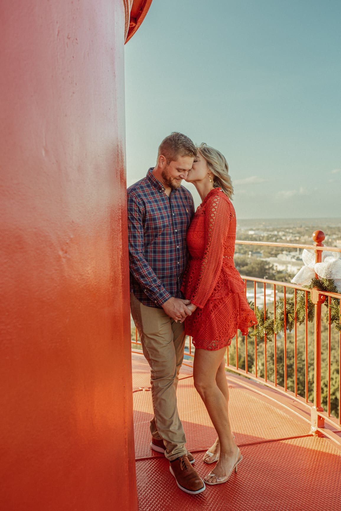 Woman kissing her fiancé's cheek at the top of the St. Augustine Lighthouse