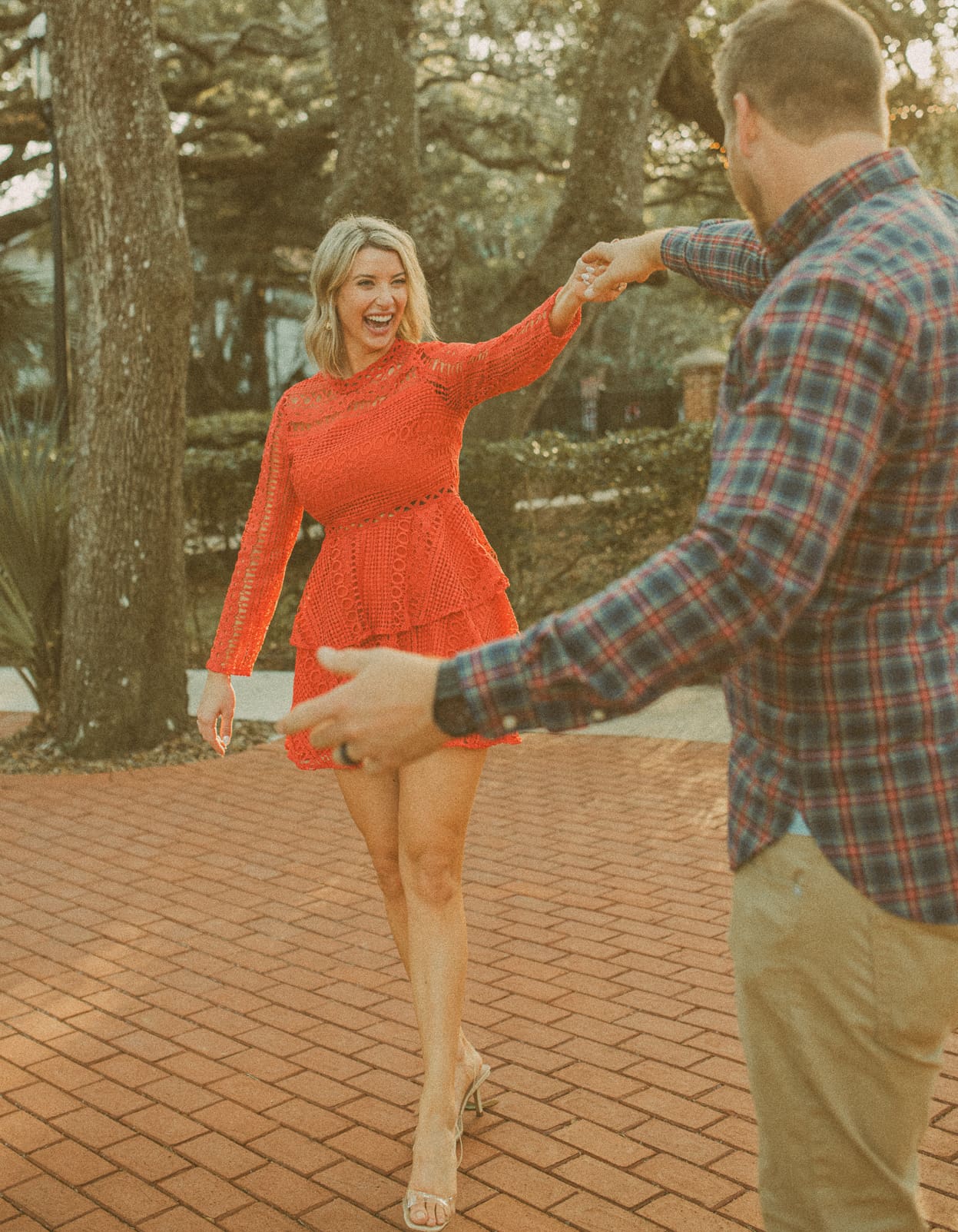 Man twirling his laughing fiancée on the brick path at the St. Augustine Lighthouse