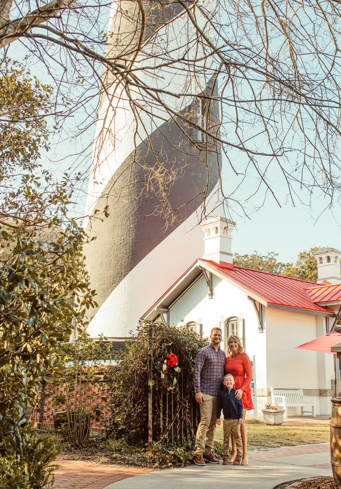 Family at the base of the St. Augustine Lighthouse framed by winter branches