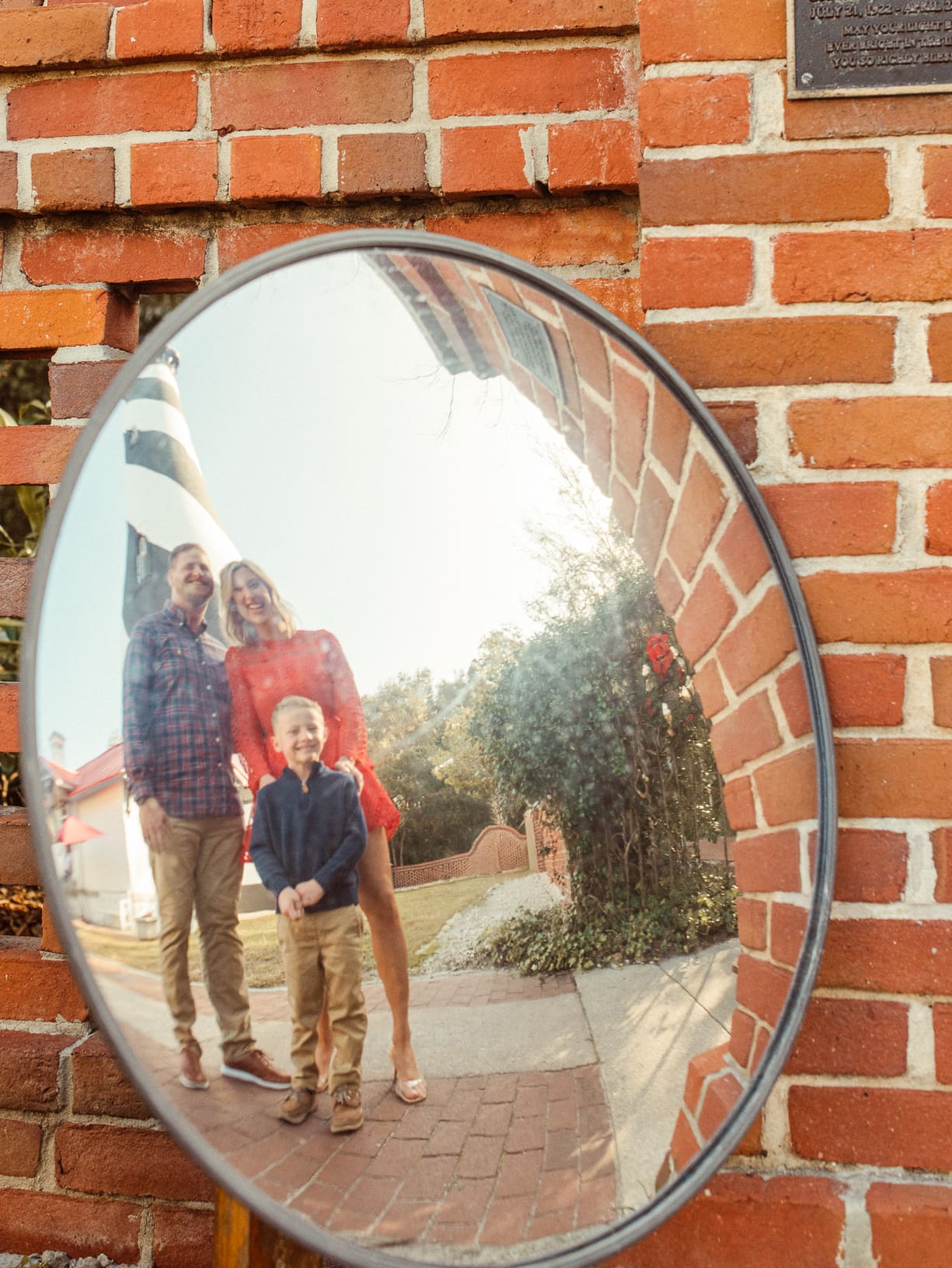 Family reflected in a round mirror on a brick wall at the St. Augustine Lighthouse