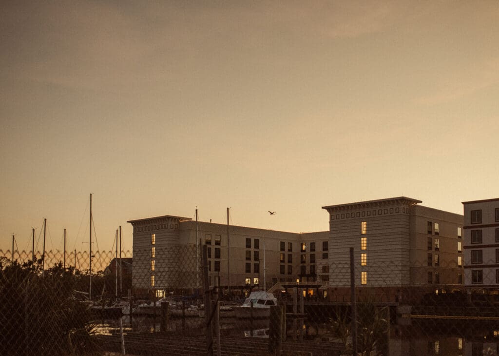 Warm sunset glow over sailboat masts and waterfront buildings in St. Augustine