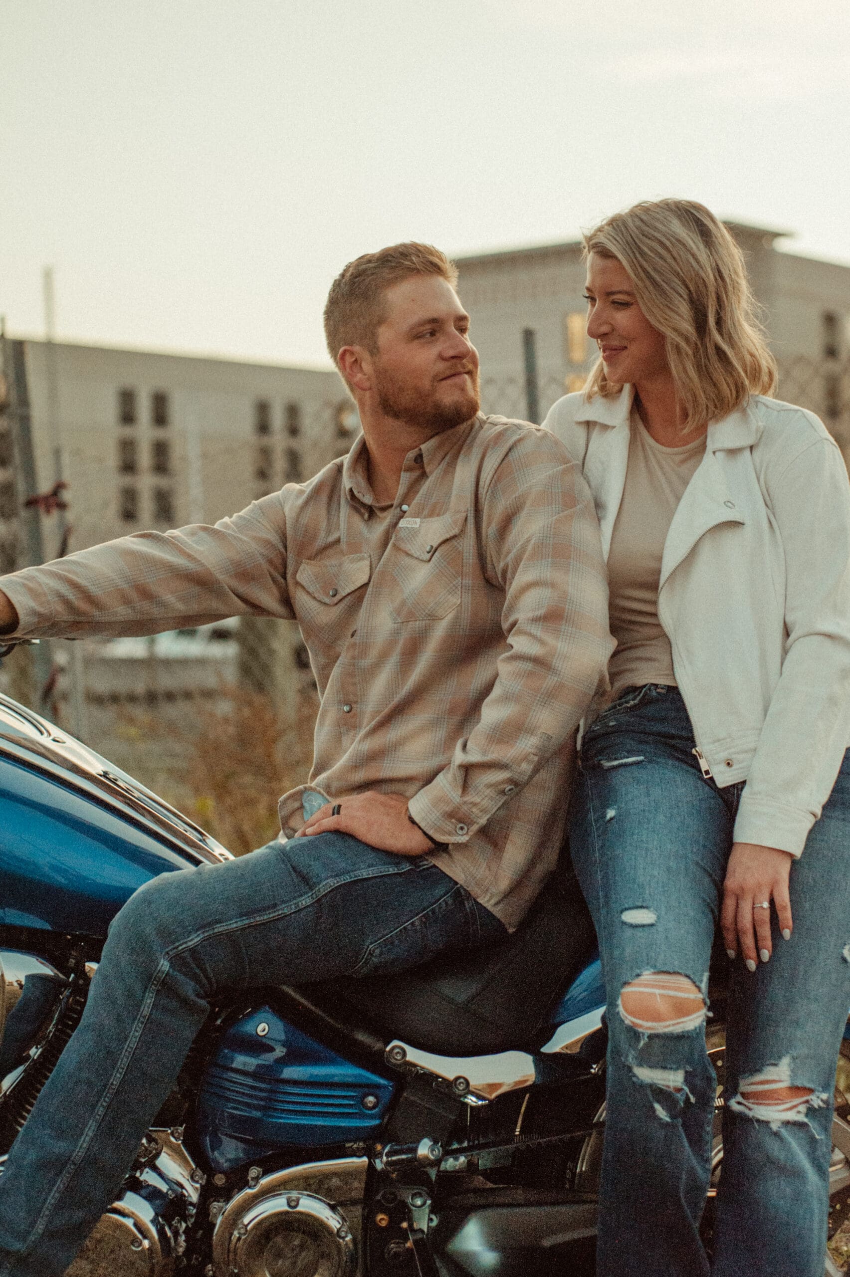 Engaged couple sitting on a blue motorcycle and gazing at each other in St. Augustine