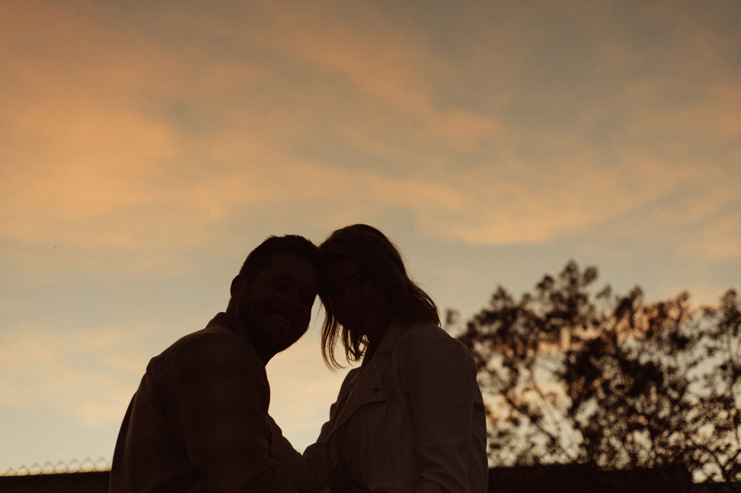 Silhouette of an engaged couple touching foreheads at sunset in St. Augustine