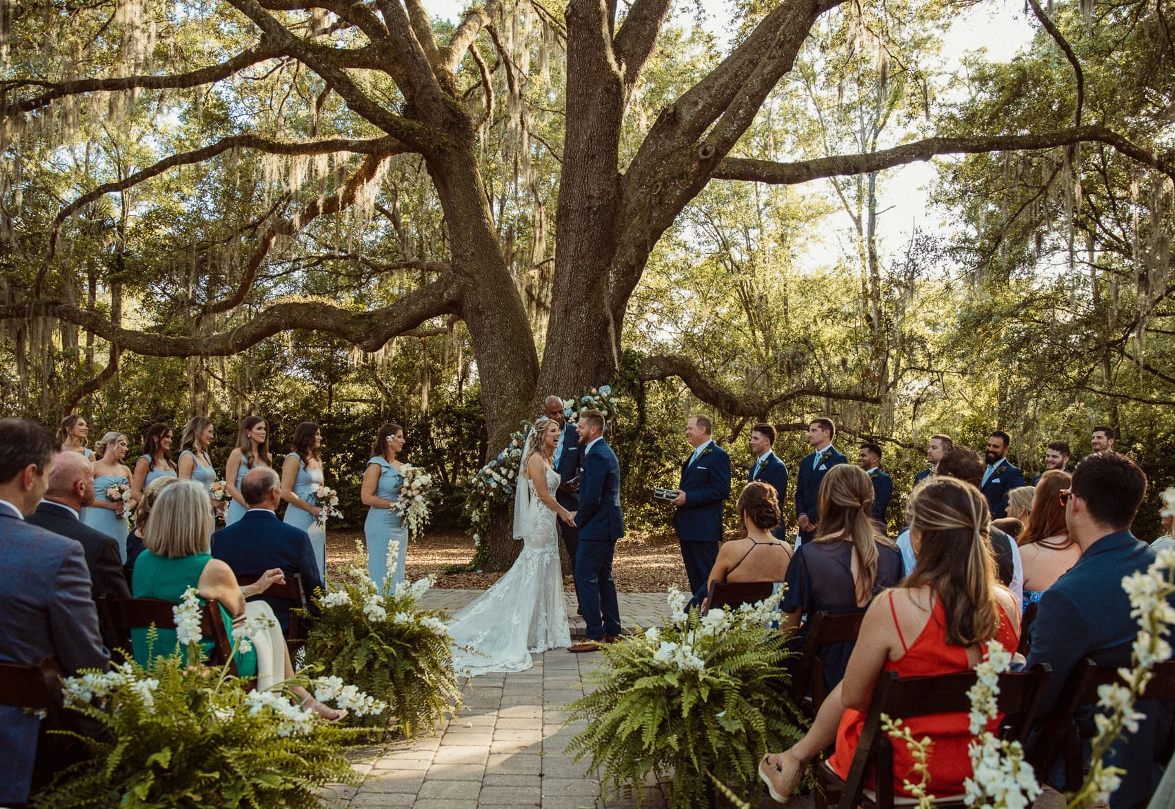 Meredith and Ryan exchanging vows beneath the oak tree at their Bowing Oaks wedding. 