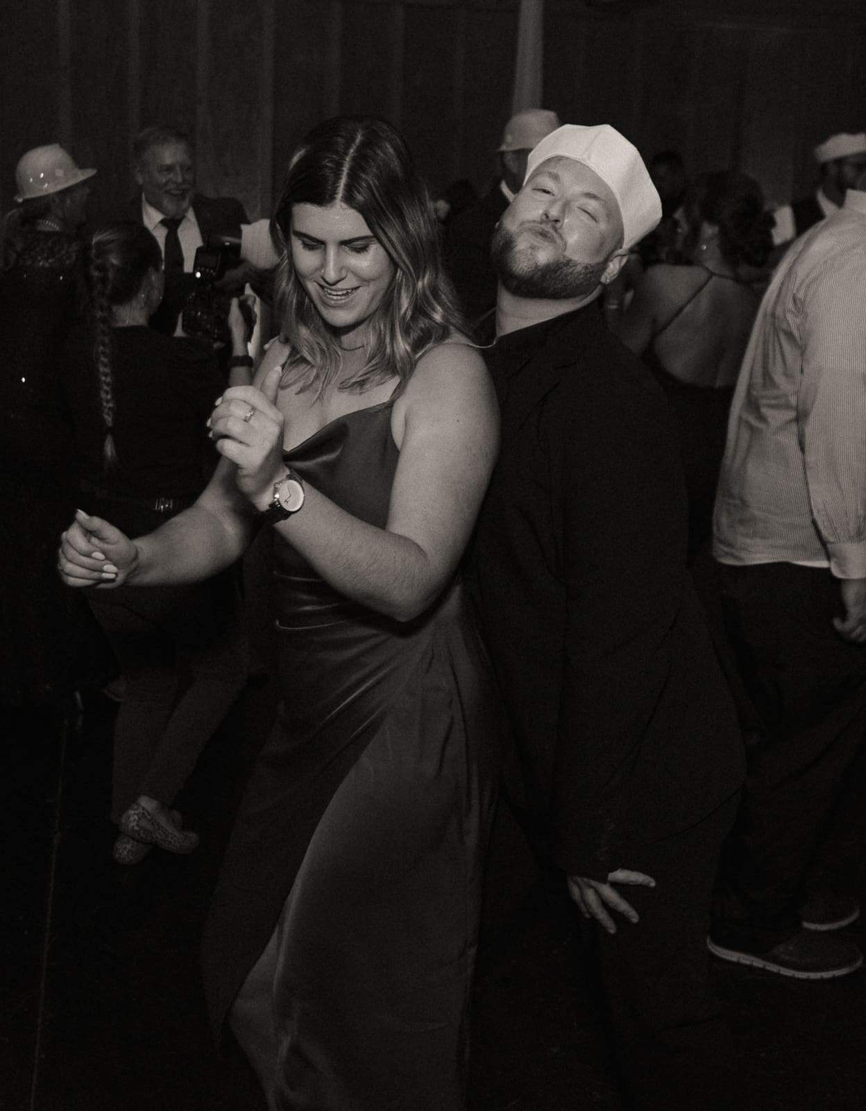 Wedding guests dancing together at Bowing Oaks reception, black and white. 