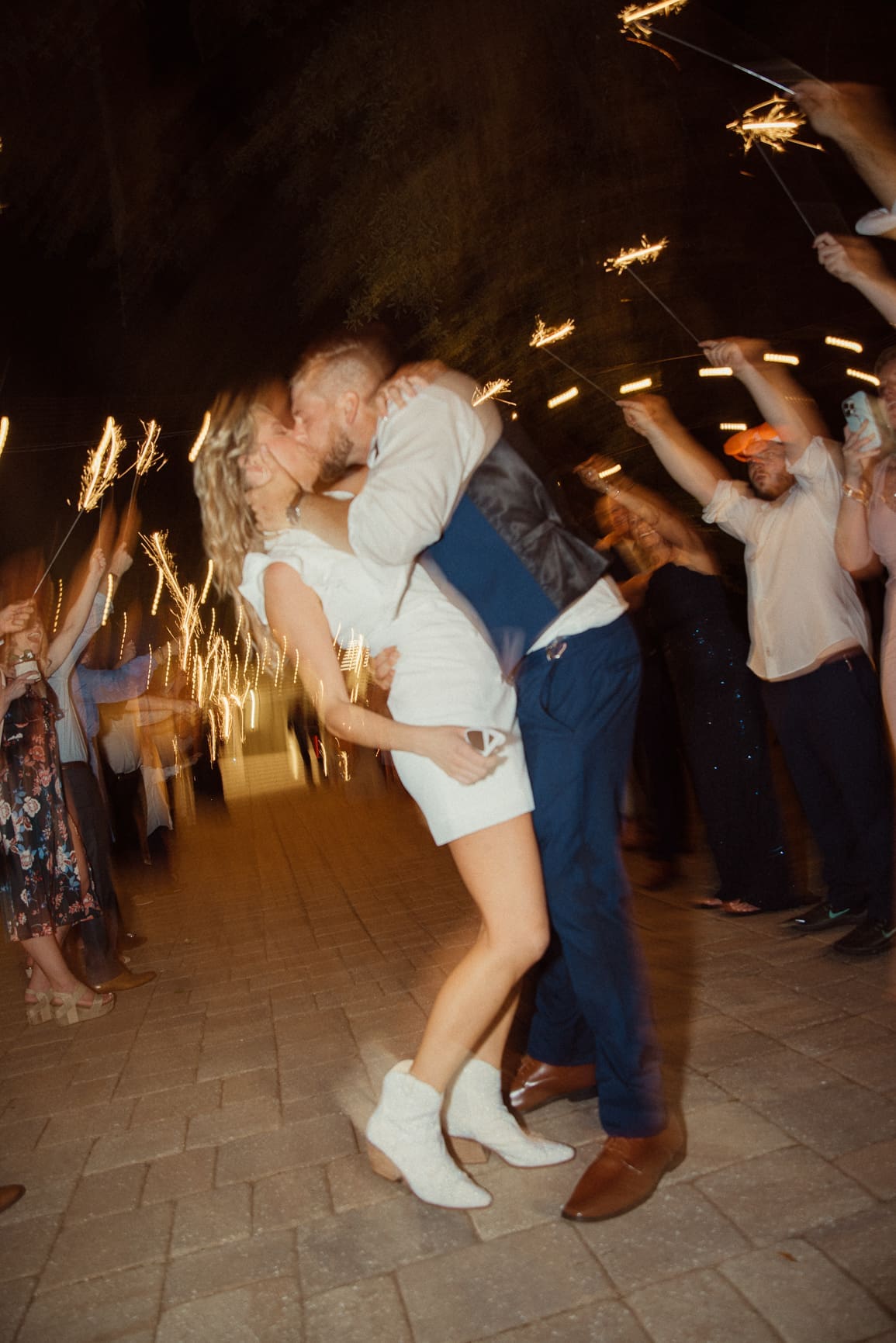 Bride and groom sharing a kiss during their sparkler send-off at Bowing Oaks wedding. 